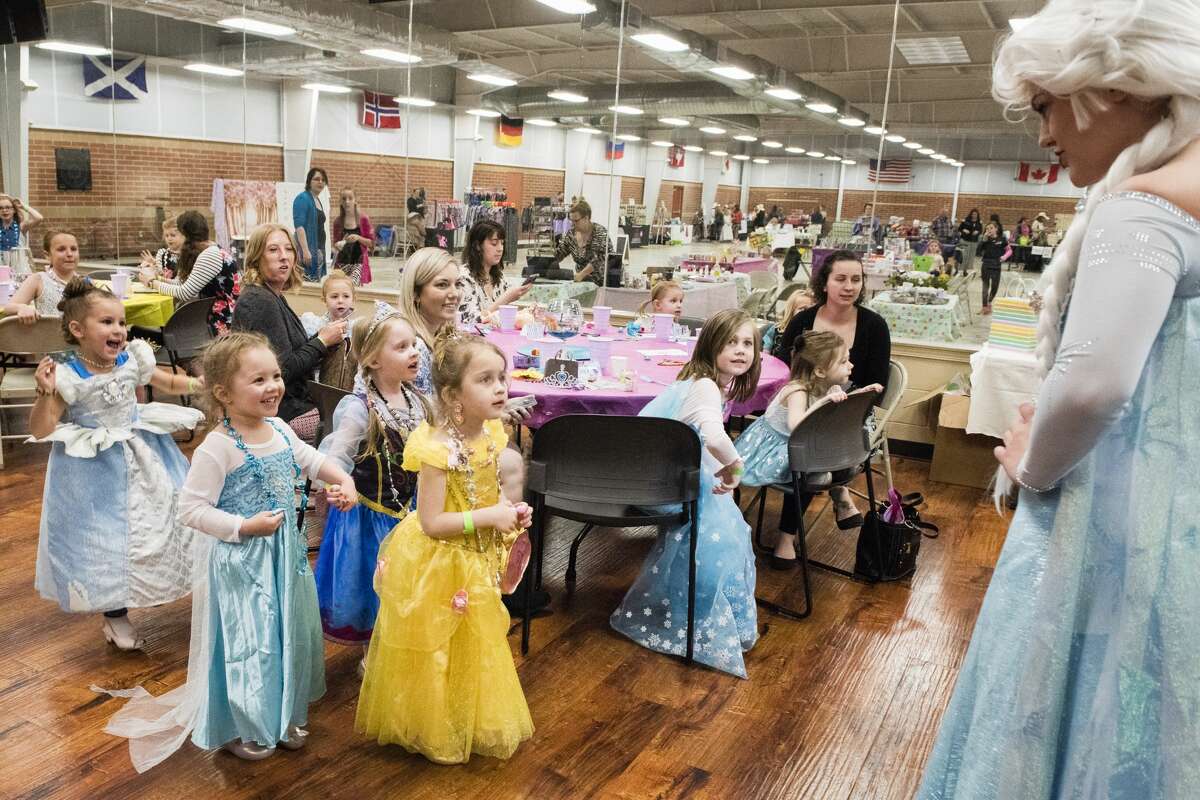 Girls dressed as princesses react to meeting "Queen Elsa" from Disney's Frozen during a Mothers and Daughters Tea Party at the Midland Curling Club on Saturday. (Danielle McGrew Tenbusch/for the Daily News)