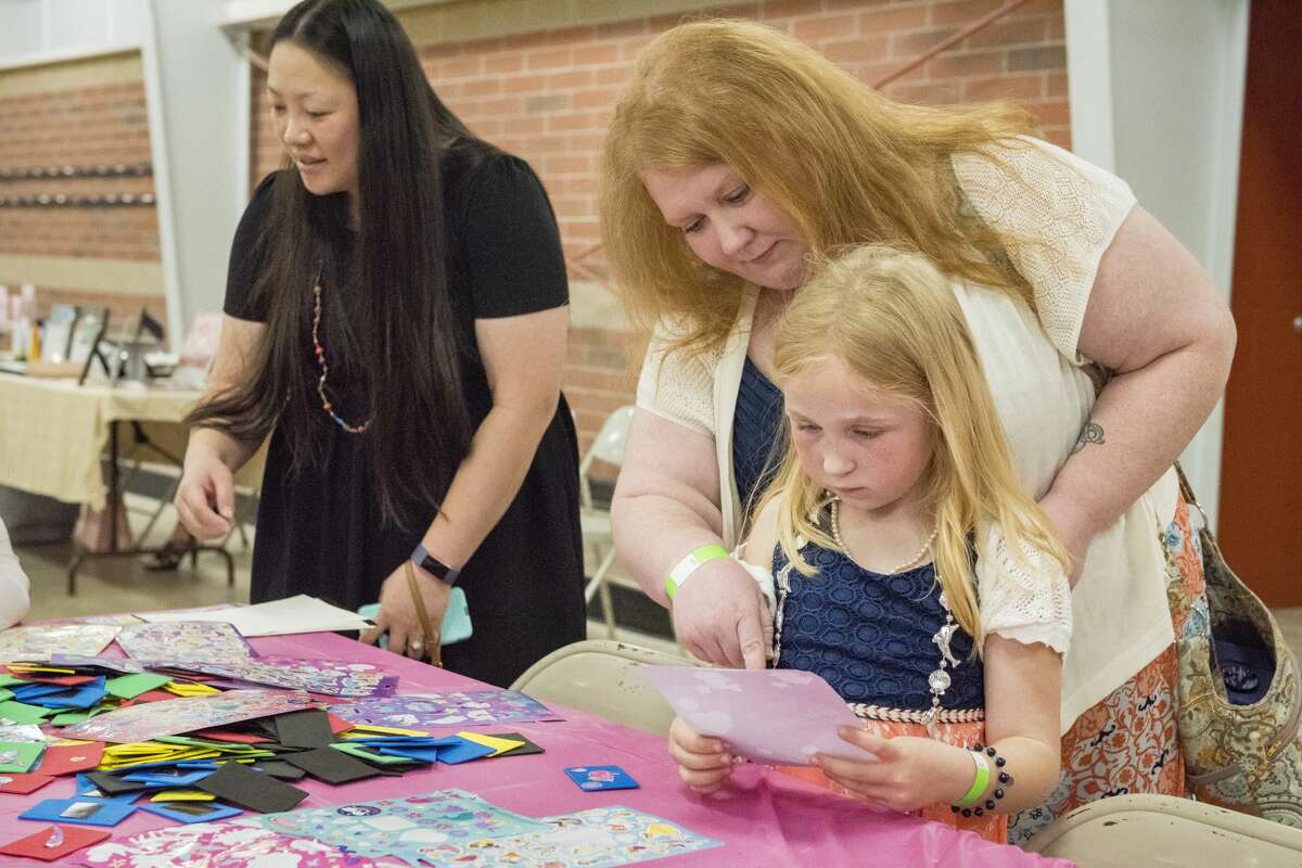 Emily Ash helps her daughter Meredith Ash, 6, pick out stickers during a Mothers and Daughters Tea Party at the Midland Curling Club on Saturday. (Danielle McGrew Tenbusch/for the Daily News)