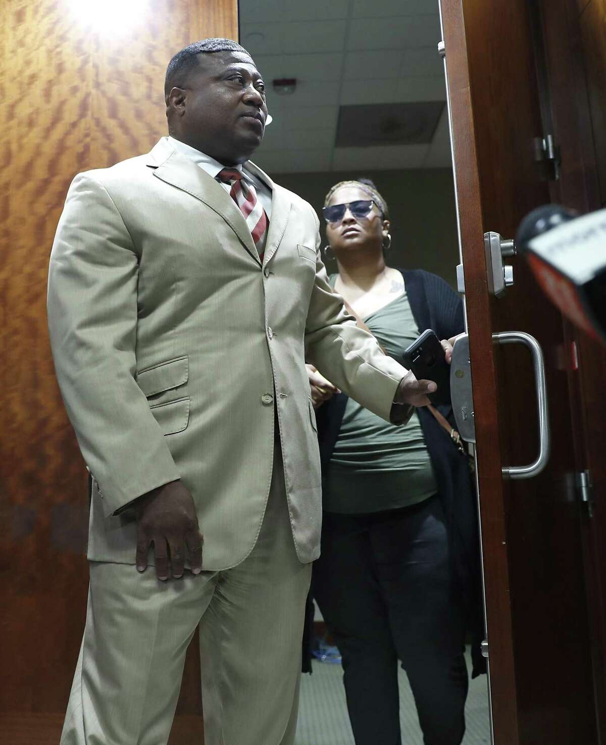 Quanell X walks out of the courtroom with Brittany Bowens, the mother of the missing 4-year-old, Maleah Davis after the court postponed a court appearance for Derion Vence, who is charged with tampering with evidence in the case of Maleah Davis' disappearance, Monday, May 13, 2019, in Houston.