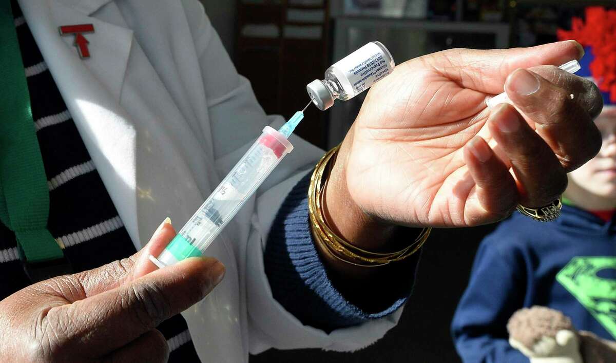 A nurse prepares to administers an influenza vaccine during a free clinic in Stamford.