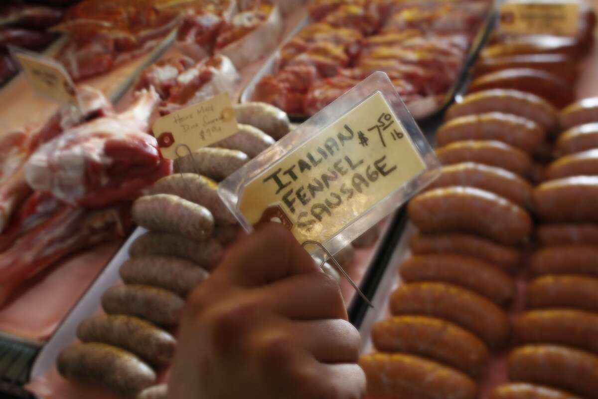 Sausage maker Tia Harrison places another fresh batch in the display case at Avedano's Market in San Francisco.