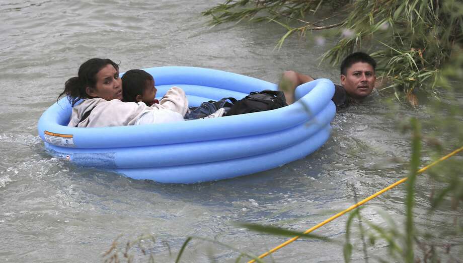 One of the Honduran fathers, pulls his wife and two children, ages 2 and 4, to safety on the U.S. side in Eagle Pass. Photo: Bob Owen