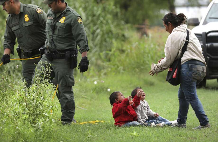 Once safely on shore, the mother tries to comfort her terrified children. The group assembled on the grass, right by an Eagle Pass golf course. Migrants are crossing the swollen Rio Grande in this Border Patrol district every day, resulting in more than 300 rescues. Photo: Bob Owen
