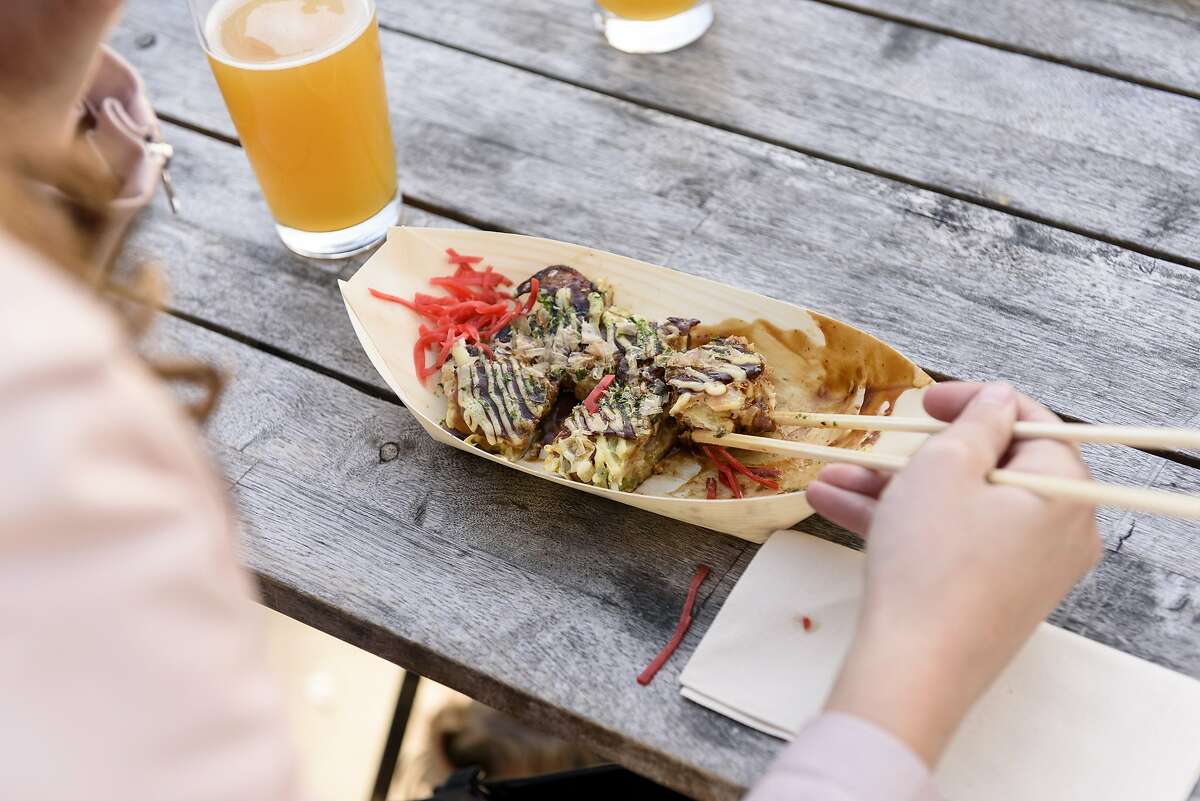 Mahalia LeClerc digs into a okonomiyaki from the Okkon pop-up at Temescal Brewery in Oakland, Calif, on Wednesday, April 17, 2019.