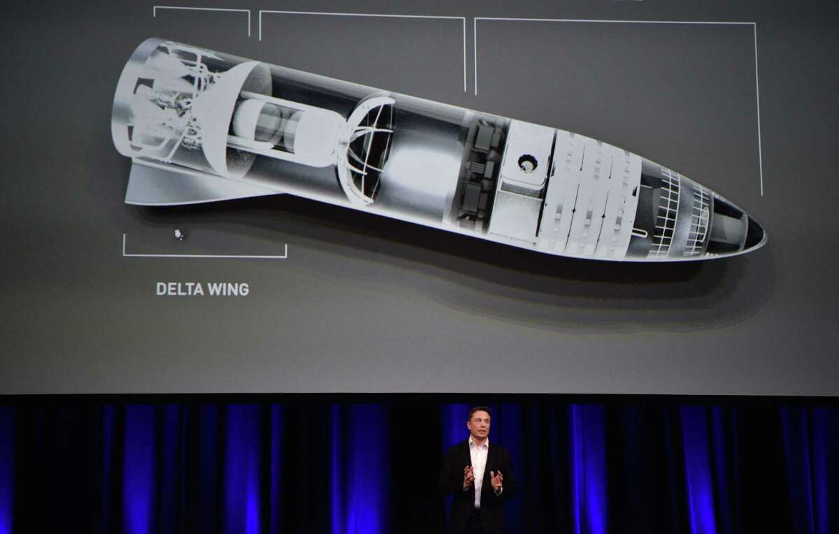 In this photo taken on Sept. 29, 2017, billionaire entrepreneur and founder of SpaceX Elon Musk speaks below a computer-generated illustration of his new rocket at the 68th International Astronautical Congress in Adelaide.