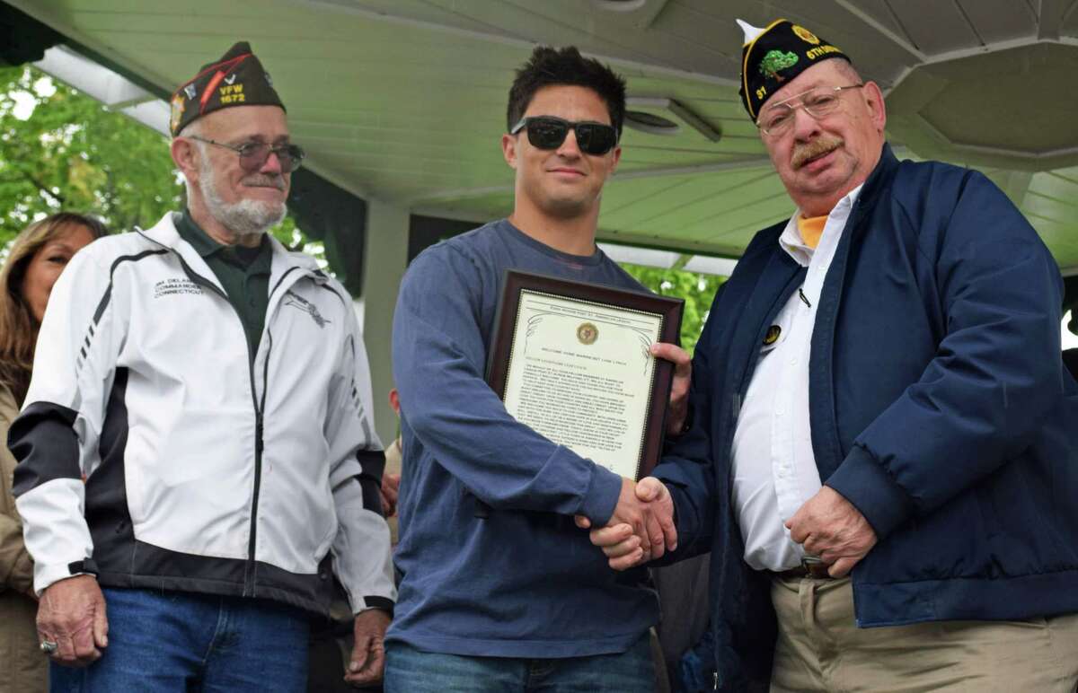 Spectrum/New Milford Marine Sgt. Liam Lynch received a surprise welcome home reception May 12, 2019 at the bandstand. Above, Ezra Woods Post 31 American Legion Commander Jeffrey McBreairty, right, presents a special welcome home certificate from the American Legion to Lynch, as Jim Delancy of the Andrew B. Mygatt Post 1672 VFW, and state commander of the VFW looks on.