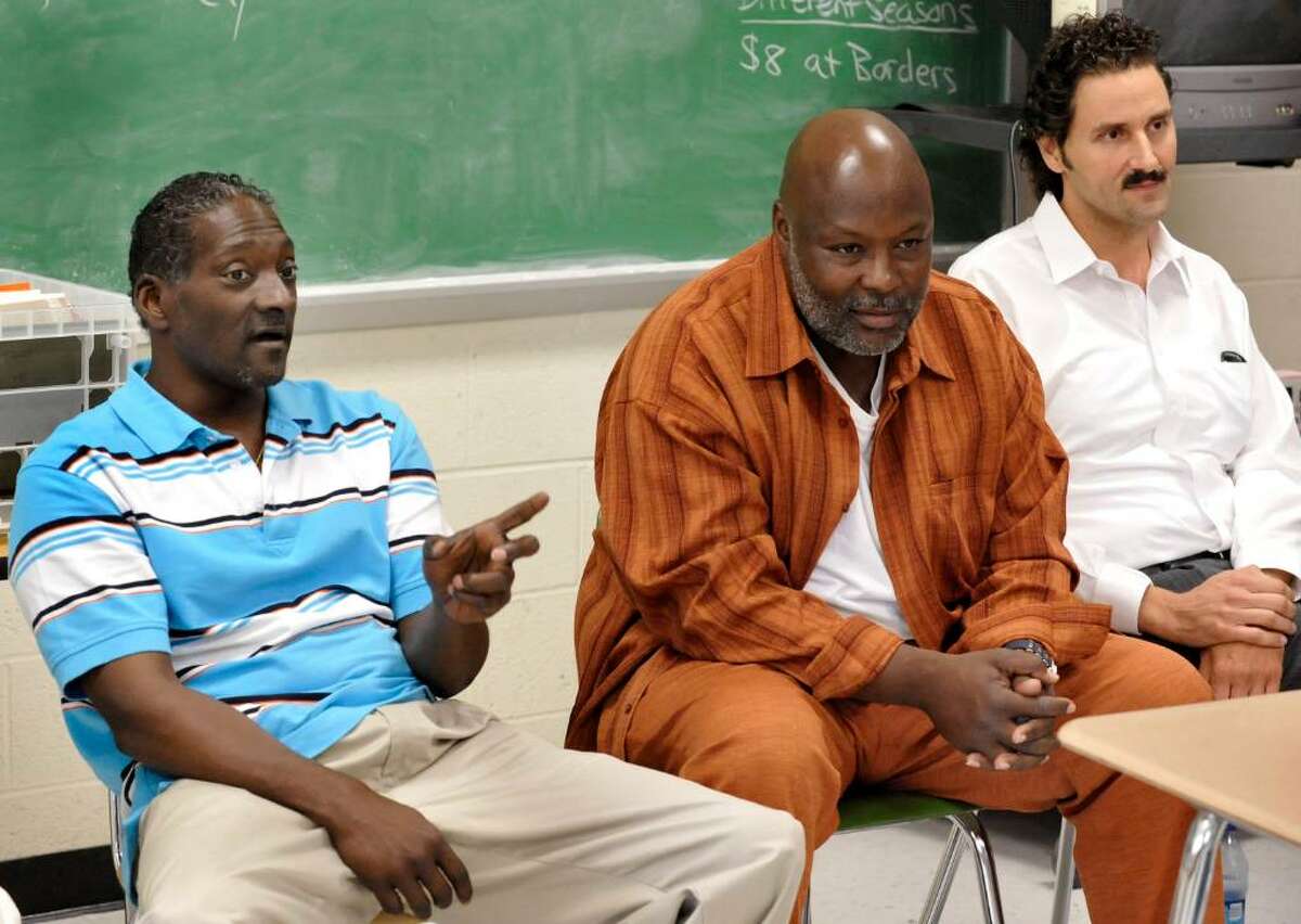 Ronald Taylor, left, and George Gould, center, accompanied by Peter Tsimbidaros, right, their attorney, talk with Bethel student during a summer school students during a program at Bethel Middle School, Wednesday, July 28, 2010. The 1993 murder conviction that sent the to prison was overturned in March.