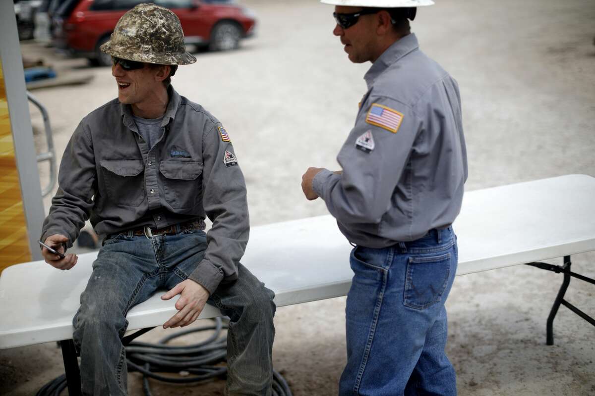 Latshaw and Diamondback personnel take a break near the base of a Latshaw Drilling Rig as the location is prepared for a media tour in 2019 in Midland County. Reporter-Telegram file photo