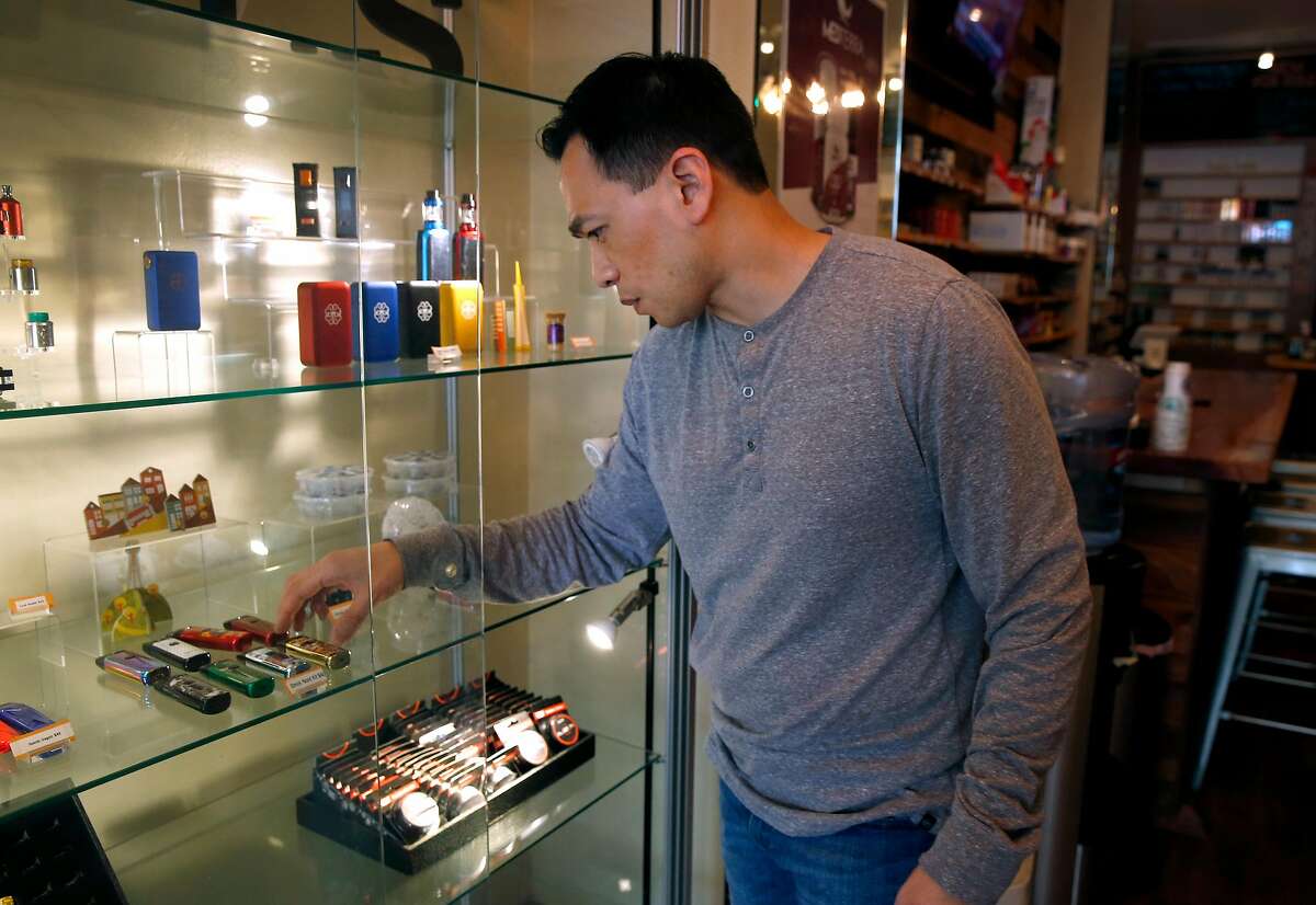 Chris Chin arranges a display of vaping devices at his Gone With the Smoke Vapor Lounge in San Francisco, Calif. on Thursday, May 9, 2019. Chin would be forced to shut down his business if proposed legislation is passed banning the sale of e-cigarettes in the city.