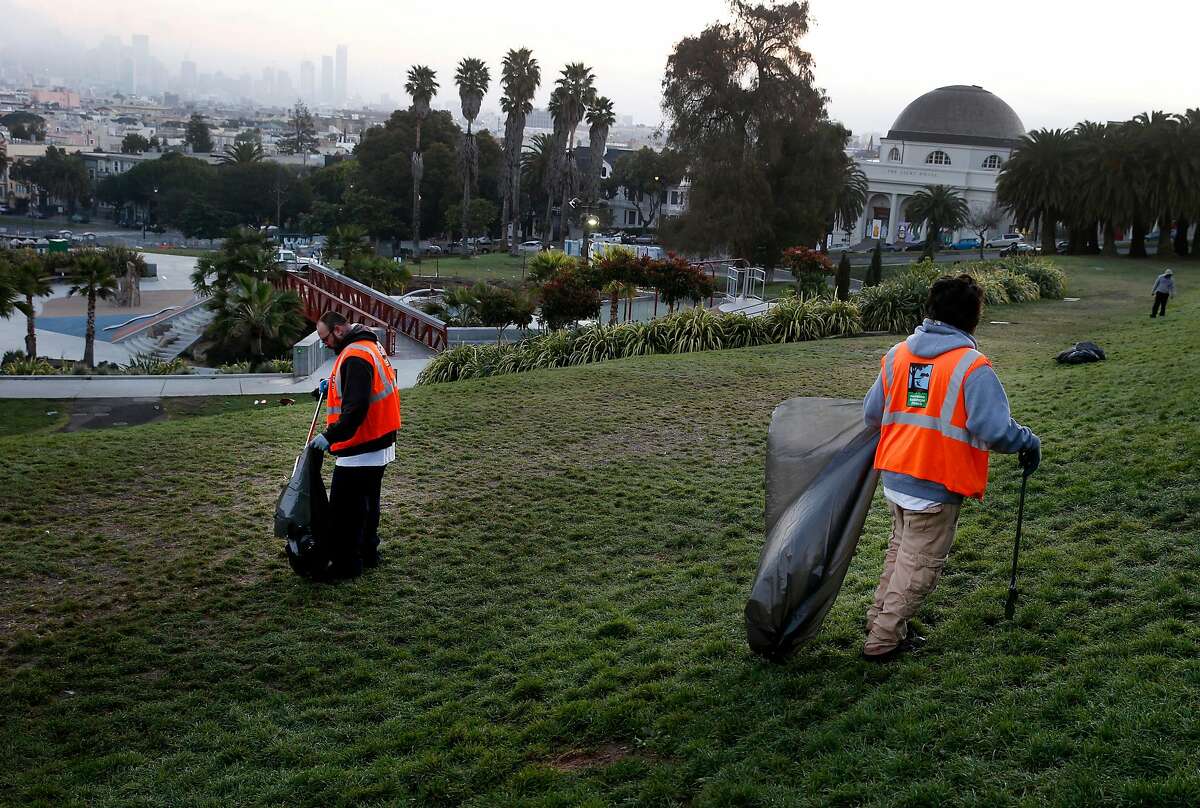 Park employees cleaning up a mess of trash in Dolores Park in 2015. The cleanliness of streets and public facilities was an issue in the 2019 biennial San Francisco survey of residents.