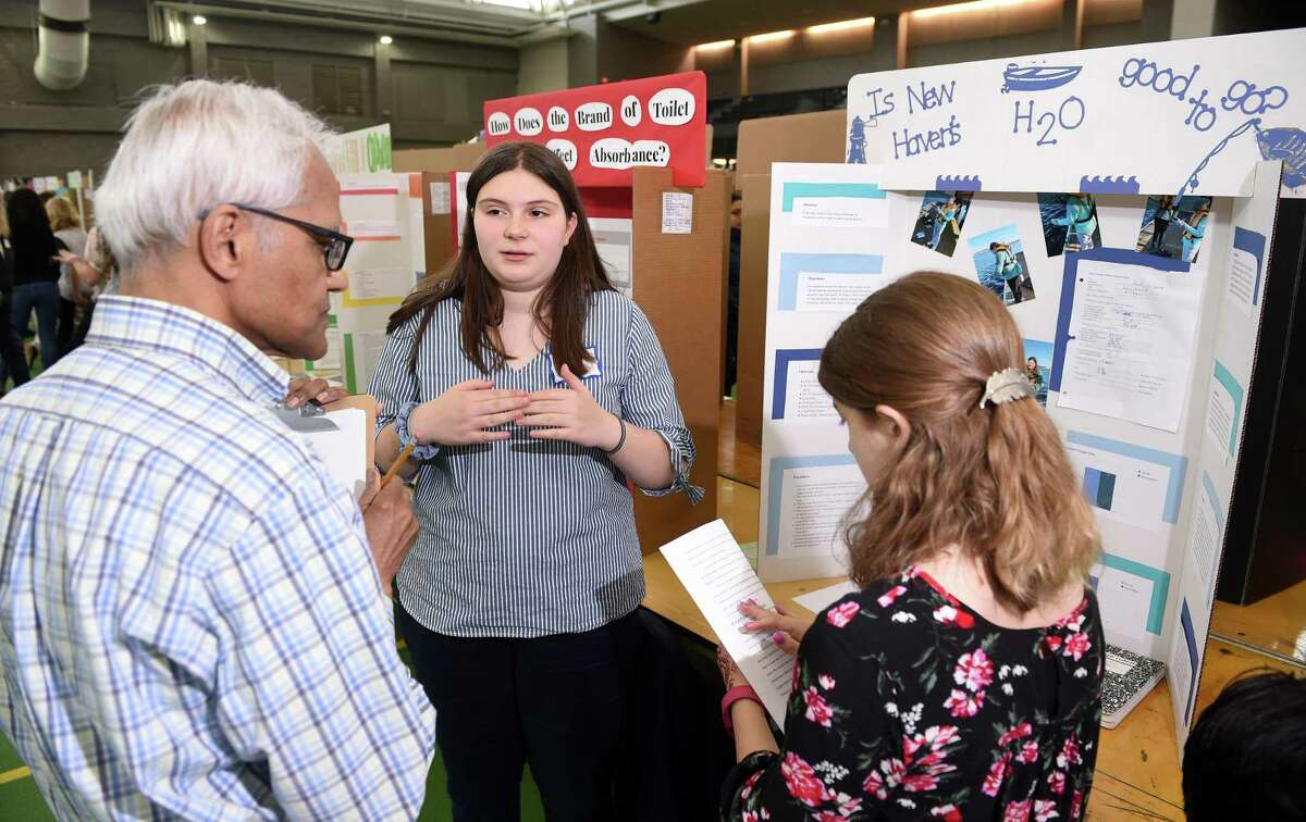 Judge Himadri Samanta (left) of the University of New Haven listens to seventh graders Mila Volpe (center), 12, and Sophia Perrone, 13, of Edgewood School in New Haven explain their project about the quality of water in New Haven for recreational usage during the 25th Annual New Haven Science Fair at the Floyd Little Athletic Center in New Haven on May 14, 2019.