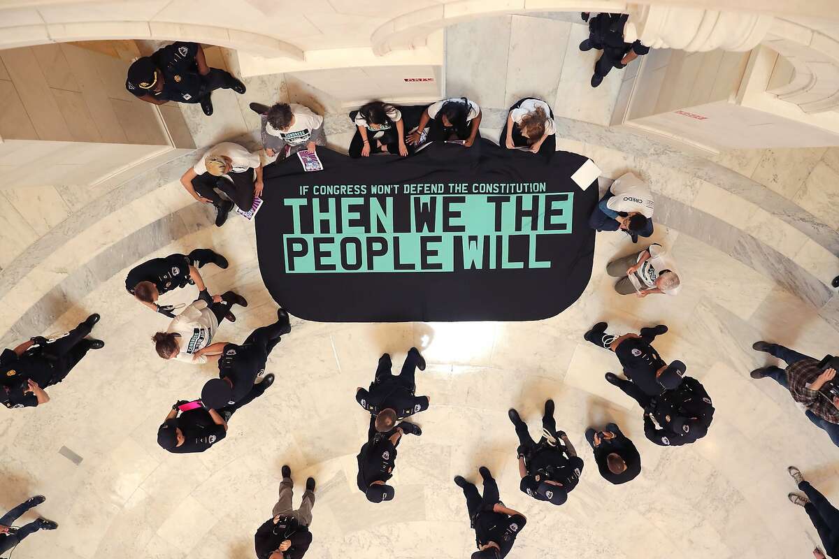 *** BESTPIX *** WASHINGTON, DC - MAY 14: Demonstrators from the pro-impeachment group By the People rally in the Cannon House Office Building Rotunda on Capitol Hill May 14, 2019 in Washington, DC. About 10 members of the protest group were arrested by U.S. Capitol Police while demanding that impeachment proceedings against President Donald Trump begin immediately. (Photo by Chip Somodevilla/Getty Images)