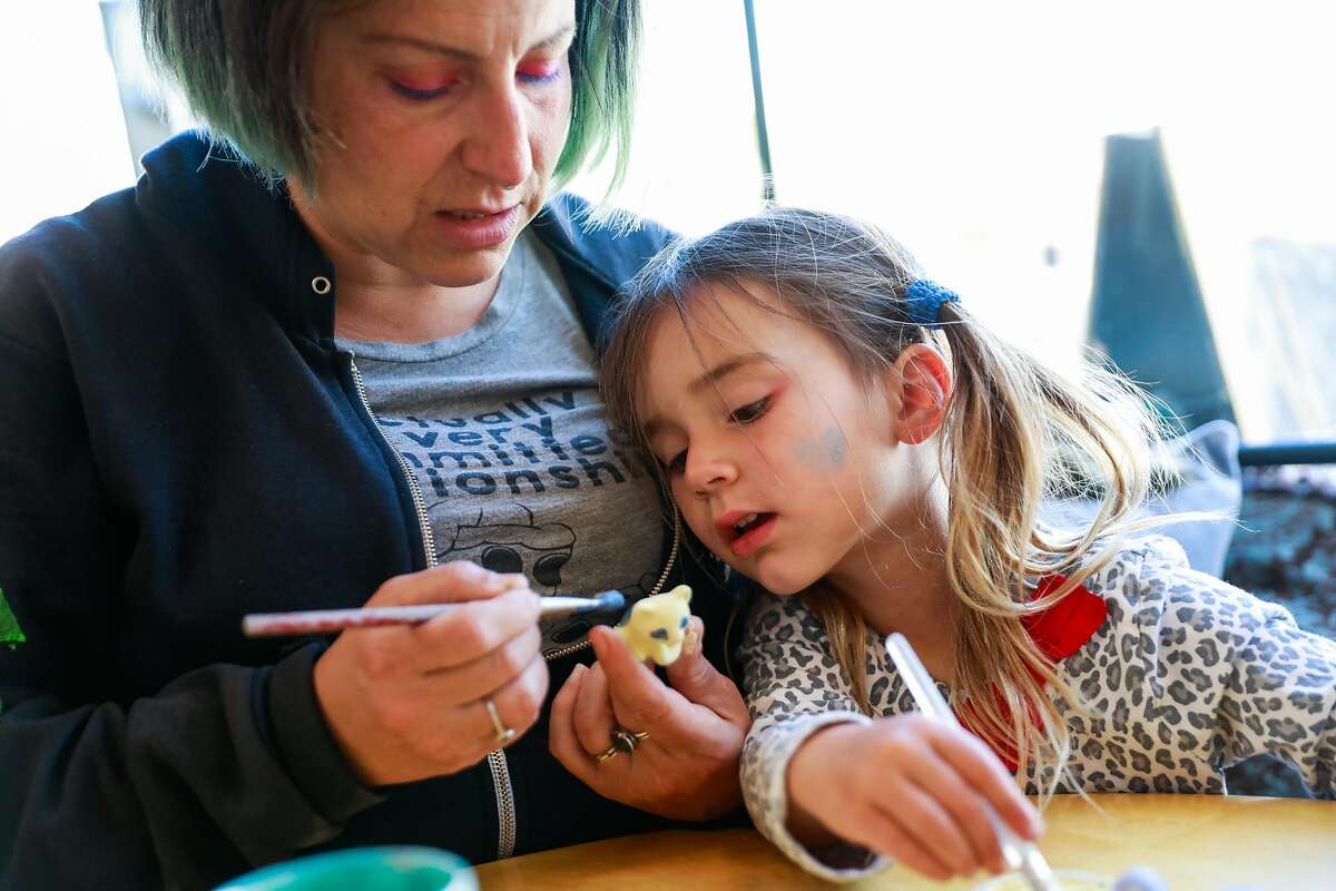 (l-r) Tink Moss and her daughter Genevieve Moss, 3, paint pottery at Terra Mia in Noe Valley in San Francisco, California, on Tuesday, April 30, 2019.