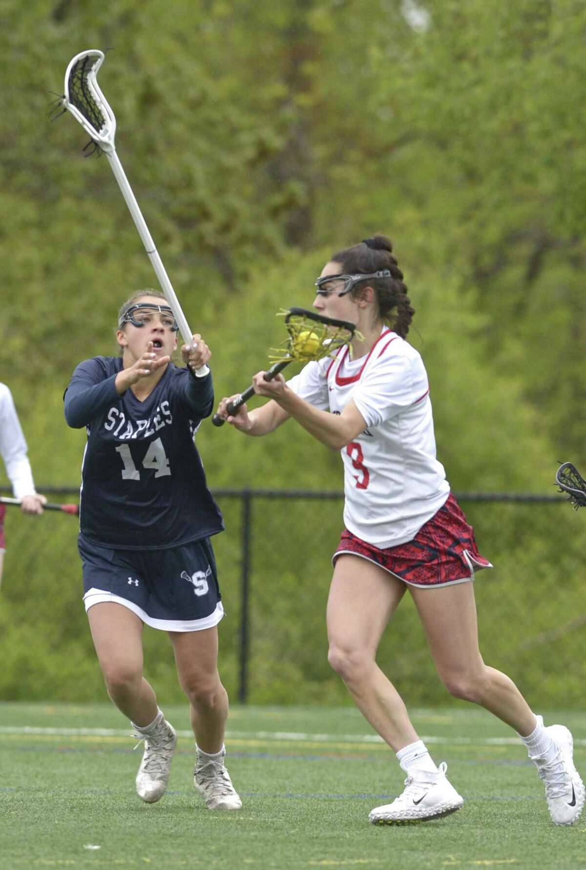 New Fairfield's Katelyn Sousa (9) moves to the goal while being defended by Staples Julia DiConza (14) in the girls lacrosse game between Staples and New Fairfield high schools, Tuesday May 14, 2019, at New Fairfield High School, New Fairfield, Conn.