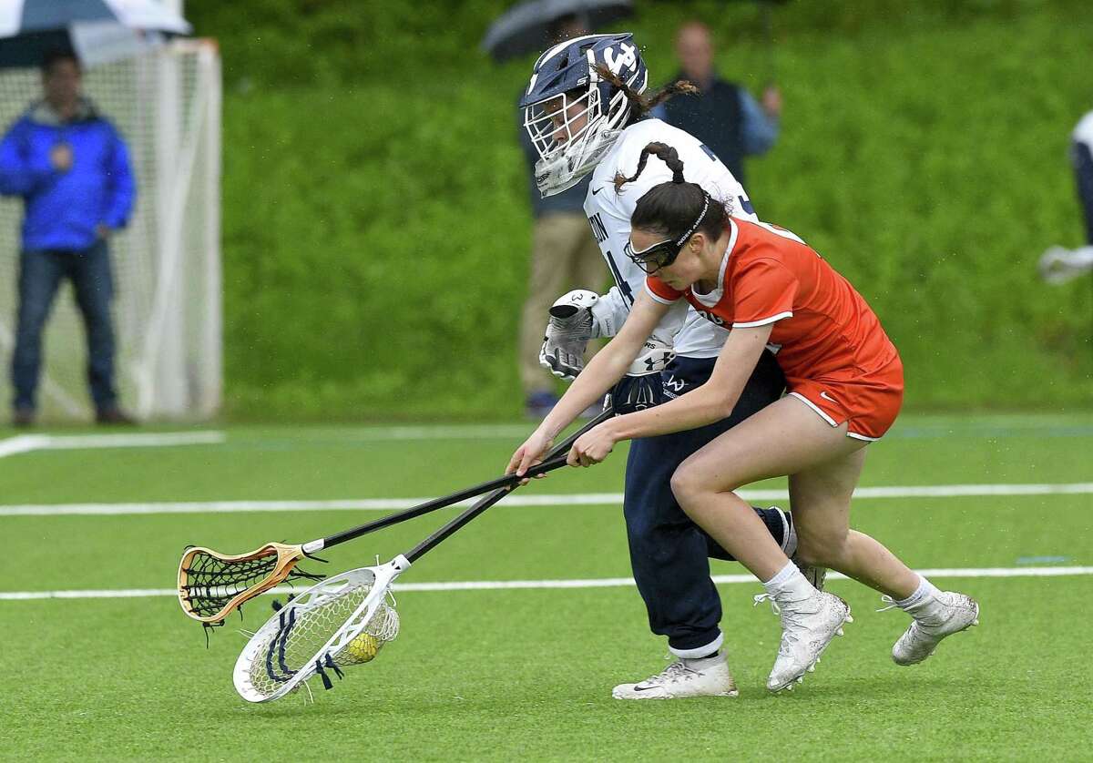 Wilton goalie Bridgette Wall defends the ball from Ridgefield's Hannah Boylan in a girls lacrosse game at Wilton High School on May 14, 2019 in Wilton, Connecticut. Ridgefield defeated Wilton 10-8.