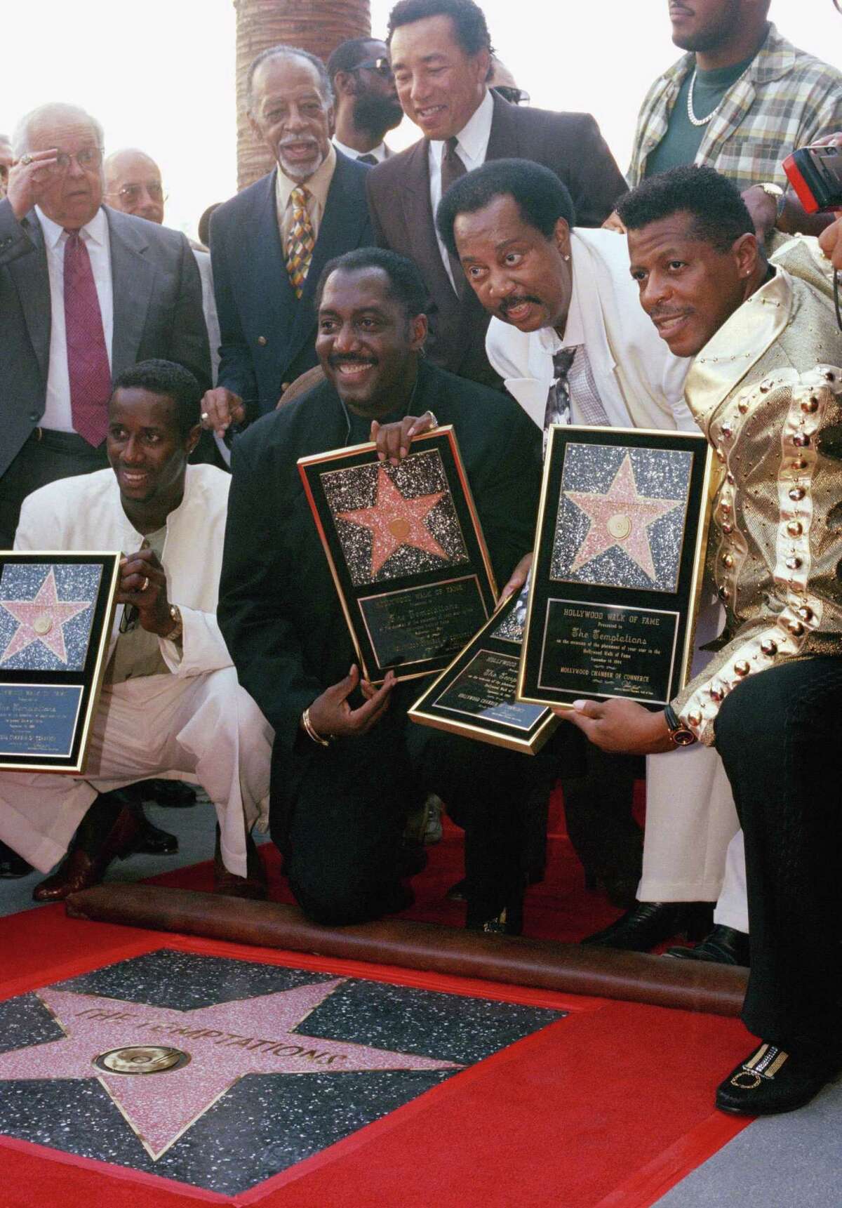 Smokey Robinson, rear, watches as Otis Williams and The Temptations get a star on the Hollywood Walk of Fame in 1994.