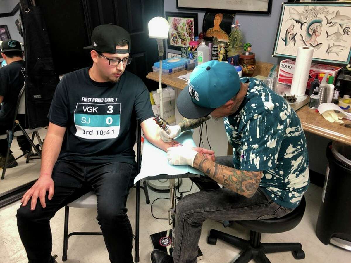 Milpitas resident Jeremy Cruz, 23, gets a free Sharks tattoo courtesy of tattoo artist Javier Gonzalez on Wednesday, May 15, 2019, at Players Ink in San Jose, Calif.