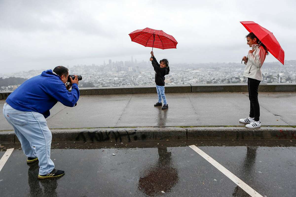 Hiten Ganatra takes pictures of his daughters Rudranshi, 5, and Mahti, 16, in the rain at Twin Peaks on Wednesday, May 15, 2019 in San Francisco, Calif.