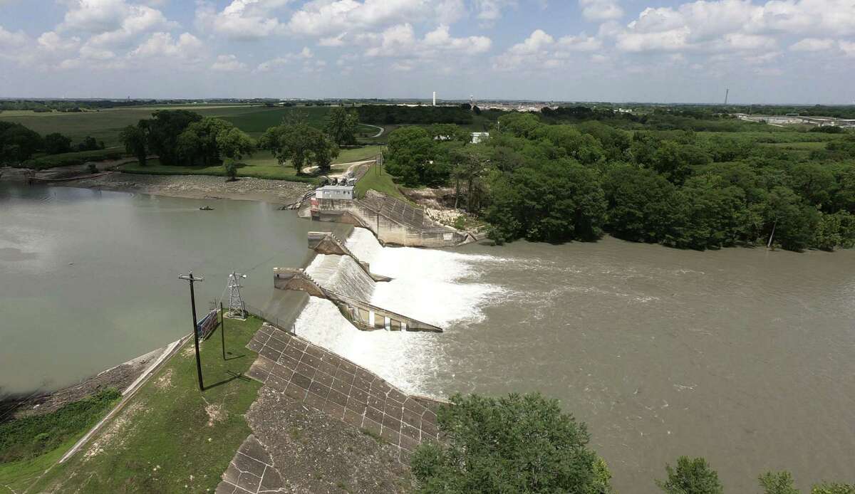 The dam on Lake Dunlap continues to spill water on May 15, 2019, the day after a middle spillway gate gave way. Much of the lake is draining.