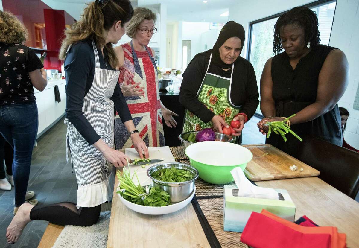 Michelle Jennings, left, Sophy Ashworth, Wafdia ibrahim and Valerie Cramer prepare vegetables during a dinner party, featuring foods from Syria, on Saturday, March 23, 2019, at Ashworth's home in Houston. Ibrahim sought refuge in the U.S. from Homs, Syria, about three years ago, and has since found that cooking has been her best option to to earn a living. She has started private cooking classes for native Houstonians in her and their homes.