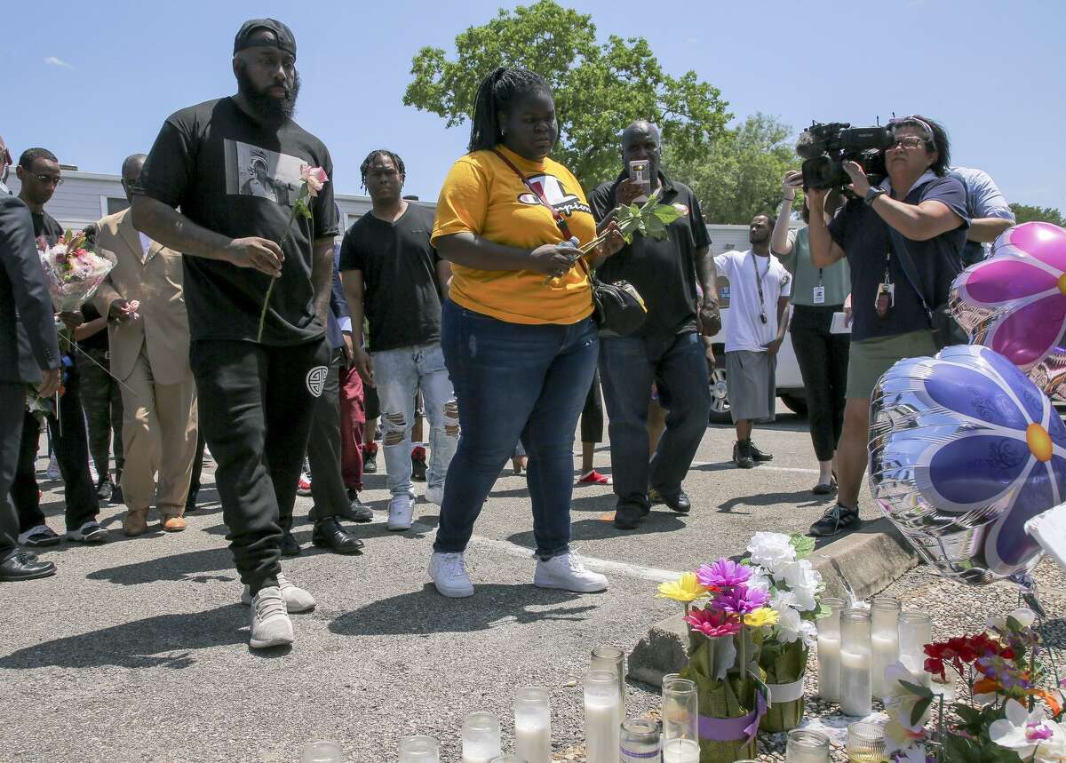 Chelsie Ruben, center, alongside with Houston rapper Trae the Truth, left, drop off roses at the memorial at the Brixton Apartments complex in Baytown, Texas, Wednesday, May 15, 2019, for her mother, Pamela Turner, who was killed Monday night during a confrontation with a Baytown Police officer. (Godofredo A Vasquez/Houston Chronicle via AP)