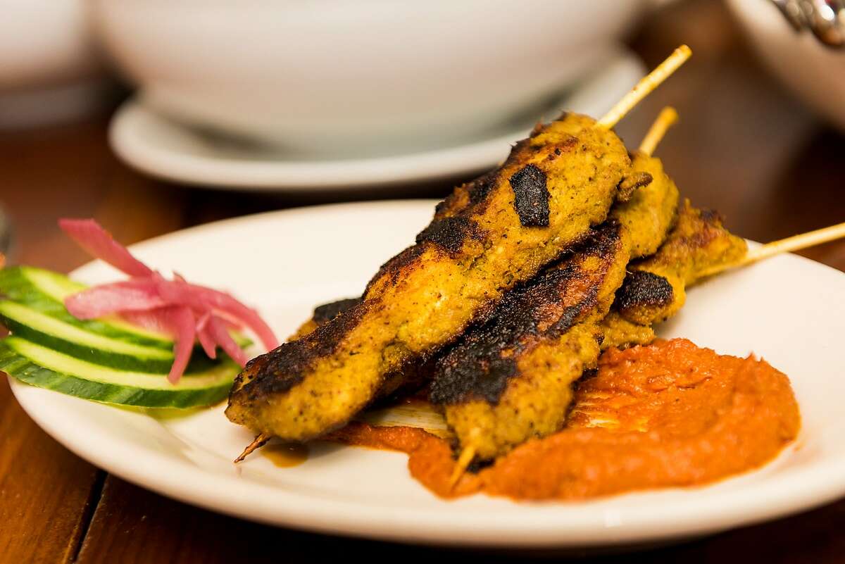 Chicken satay is served at Local Kitchen with pickled onions, cucumber and peanut sauce.