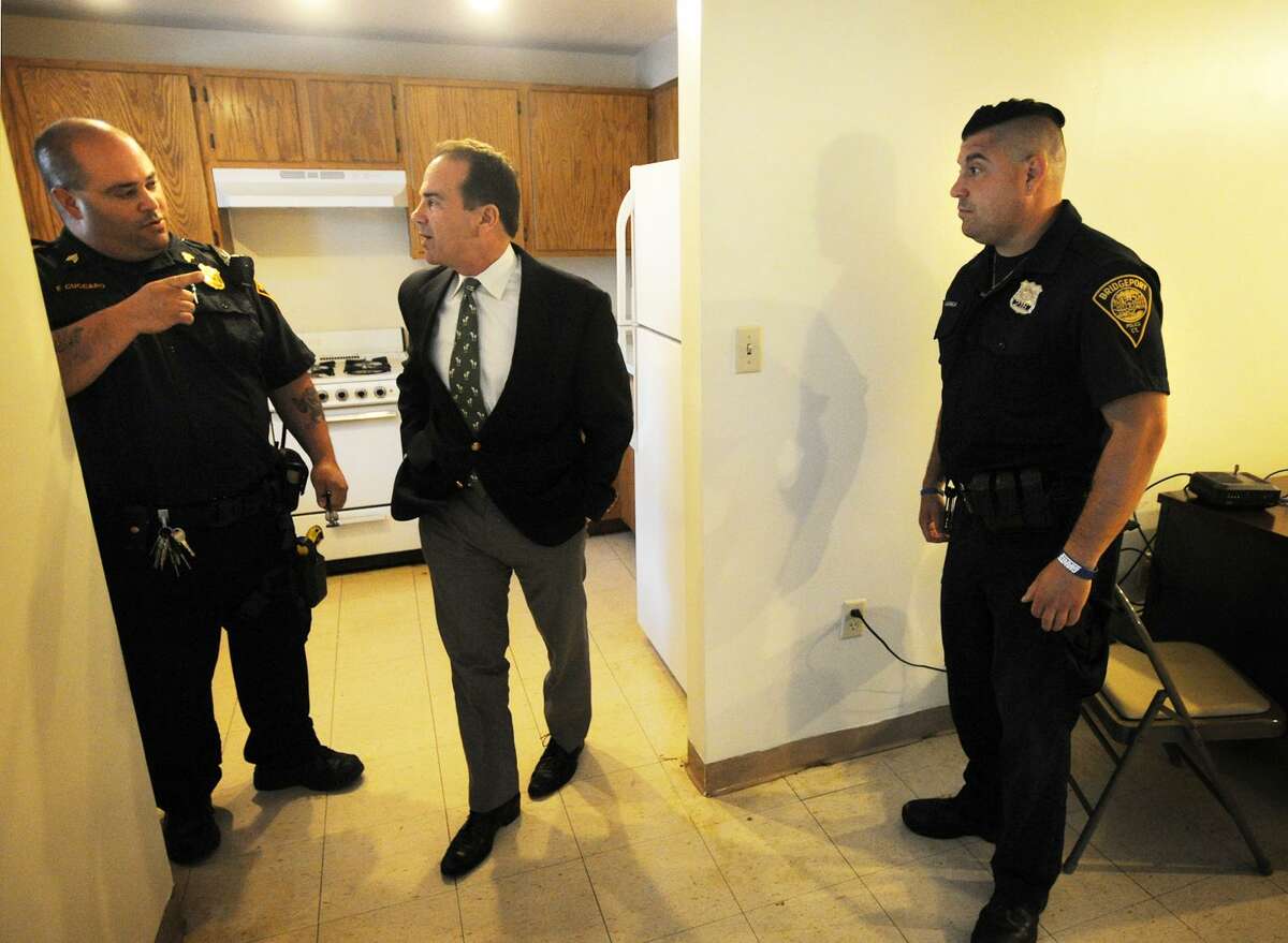 File photo: Bridgeport Mayor Joe Ganim, center, tours the reactivated police post at P.T. Barnum Apartments with Sgt. Frank Cuccaro, left, and Officer Michael Salemme in Bridgeport, Conn. on Thursday, August 17, 2017.