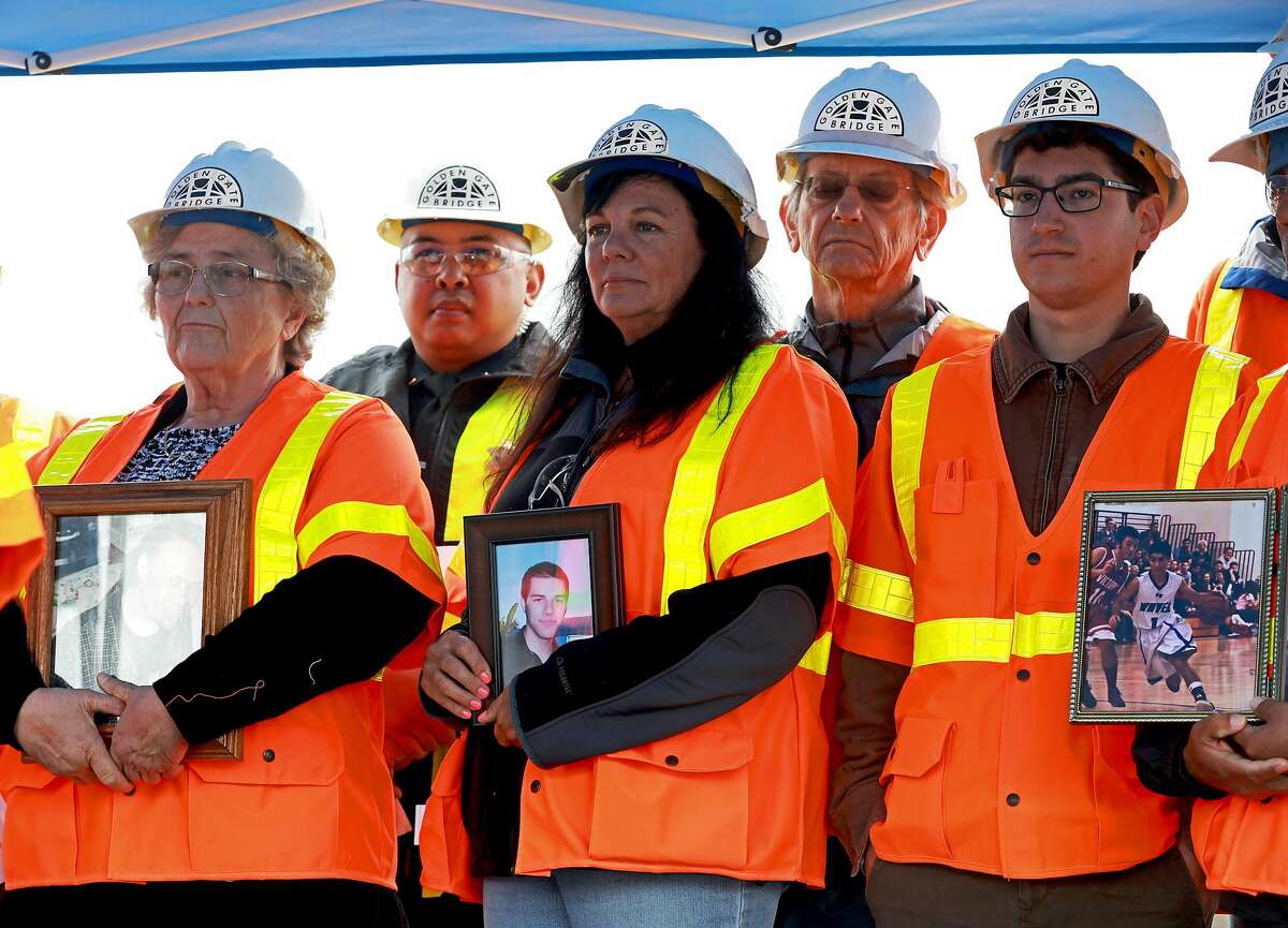 Dayna Whitmer (center) stands with other family members who've lost loved ones to jumping suicides during a press conference introducing a suicide deterrent system net at Richmond Yard in Richmond, Calif., on Thursday, May 16, 2019. Whitmer's son, Mattie, who at the age of 20, jumped from the Golden Gate Bridge on November 15, 2017. His body was never recovered. The net will be placed 20 feet below the sidewalk, extending 20 feet out from the Golden Gate Bridge. It will prevent anyone from easily jumping into the water below. "People were so upset; they thought it would ruin the look of the bridge and say it's going to make it ugly and it's not," Whitmer, of Hercules, said. "It doesn't matter because it is a bridge and the net's only going to help."