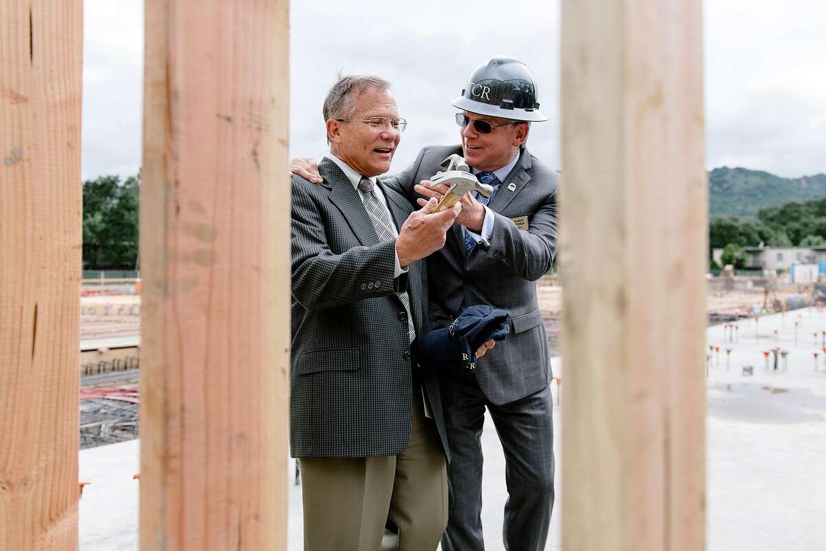 Danville mayor Robert Storer, right, hands town manager Joe Calabrigo a hammer for a nail driving ceremony during an Alexan Downtown Danville multifamily housing development framing ceremony in Danville, Calif, on Wednesday, May 15, 2019.
