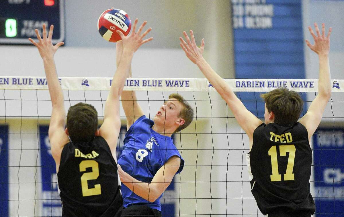 Darien's Tyler Herget (8) slams the ball past Joel Barlow's Aidan Depra (2) and Carson Teed on Thursday. Darien won 3-0 (25-12, 25-15, 25-22), closing the regular season for both teams.