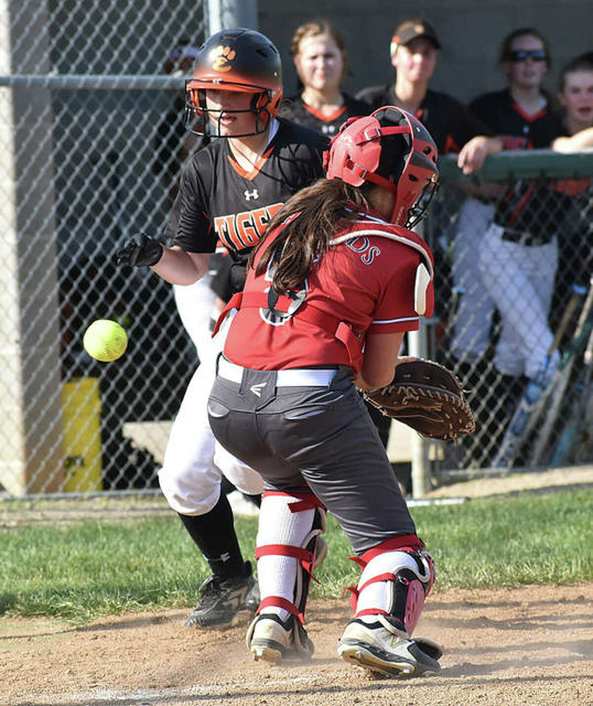Edwardsville’s Sydney Lawrence scores in the fourth inning as the ball gets away from Alton catcher Audrey Evola on Thursday in Alton.