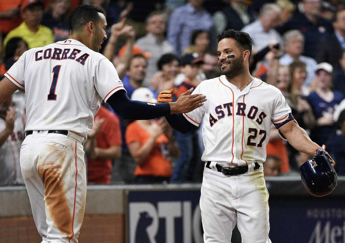 Houston Astros’ Jose Altuve celebrates a three-run home run with Carlos Correa.