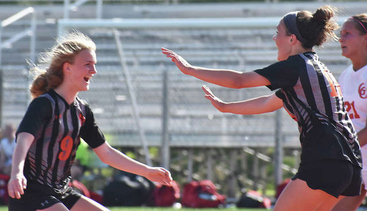 Edwardsville’s Payton Federmann, left, celebrates with Brynn Miracle after Miracle scored the game’s first goal in the 46th minute against Granite City on Friday in the Class 3A EHS Regional title game.