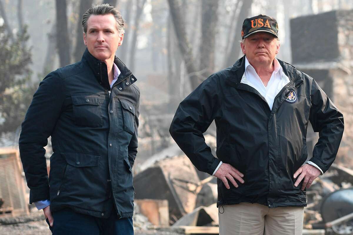 US President Donald Trump looks on with Lieutenant Governor of California, Gavin Newsom, as they view damage from wildfires in Paradise, California on November 17, 2018. Newsom recently announced his intention to withdraw most of California's National Guard troops from the border, saying the state needs tUS President Donald Trump (C) looks on with Governor of California Jerry Brown (R) and Lieutenant Governor of California, Gavin Newsom, as they view damage from wildfires in Paradise, California on November 17, 2018. The Trump administration cancelled nearly $1 billion in federal funds for California’s high-speed rail project. California Gov. hem to prepare for wildfires and to fight drug trafficking. (Photo credit should read SAUL LOEB/AFP/Getty Images)