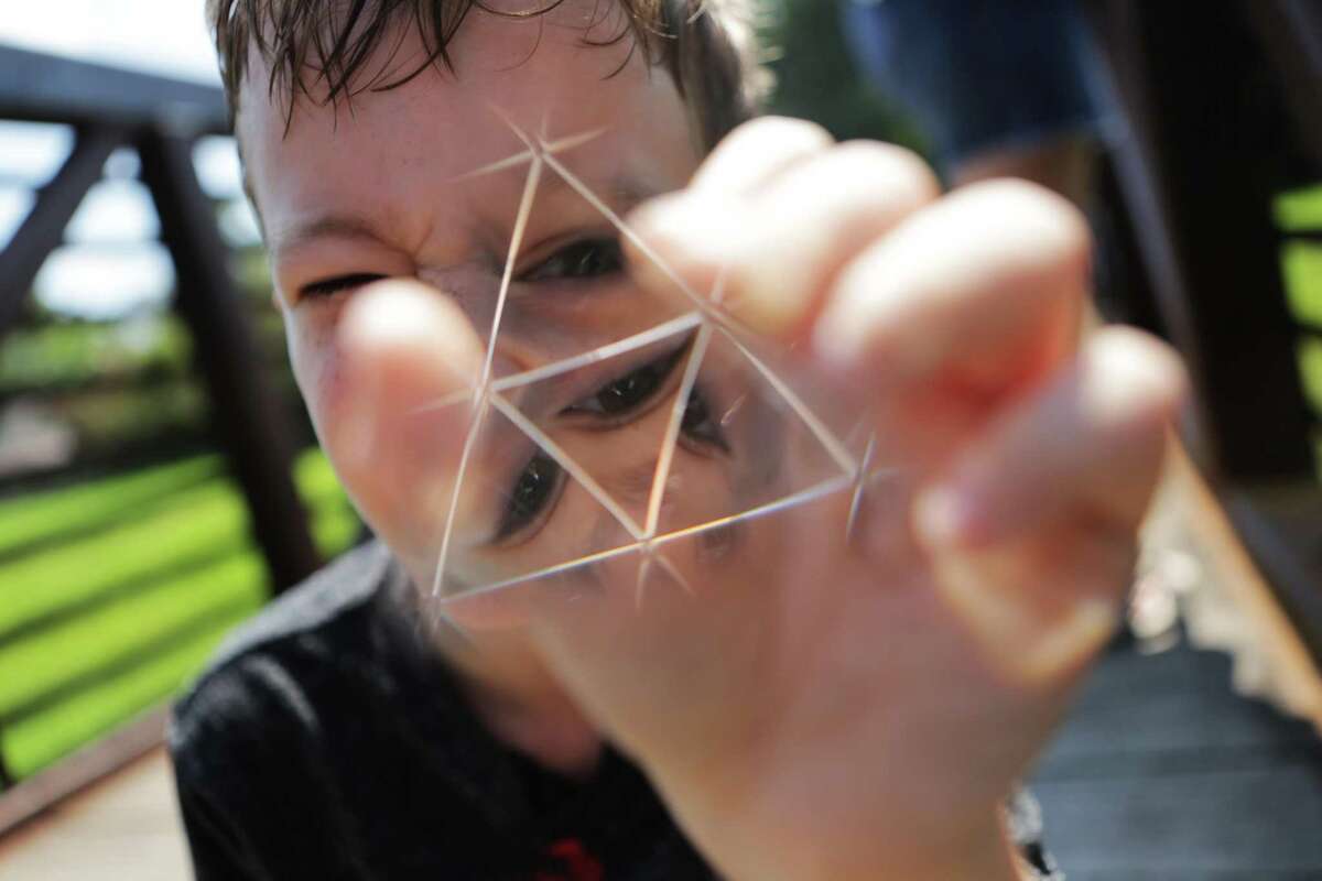 Roanin Walker's gaze disperses through the forms of a prism in face of the light on Friday, Sept. 2, 2016, in Kingwood. Walker finds comfort in science, maths and facts. He was homeschooled by his mother after been denied special education. Roanin was diagnosed with attention deficit disorder, anxiety and sensory processing disorder. ( Marie D. De Jesus / Houston Chronicle )