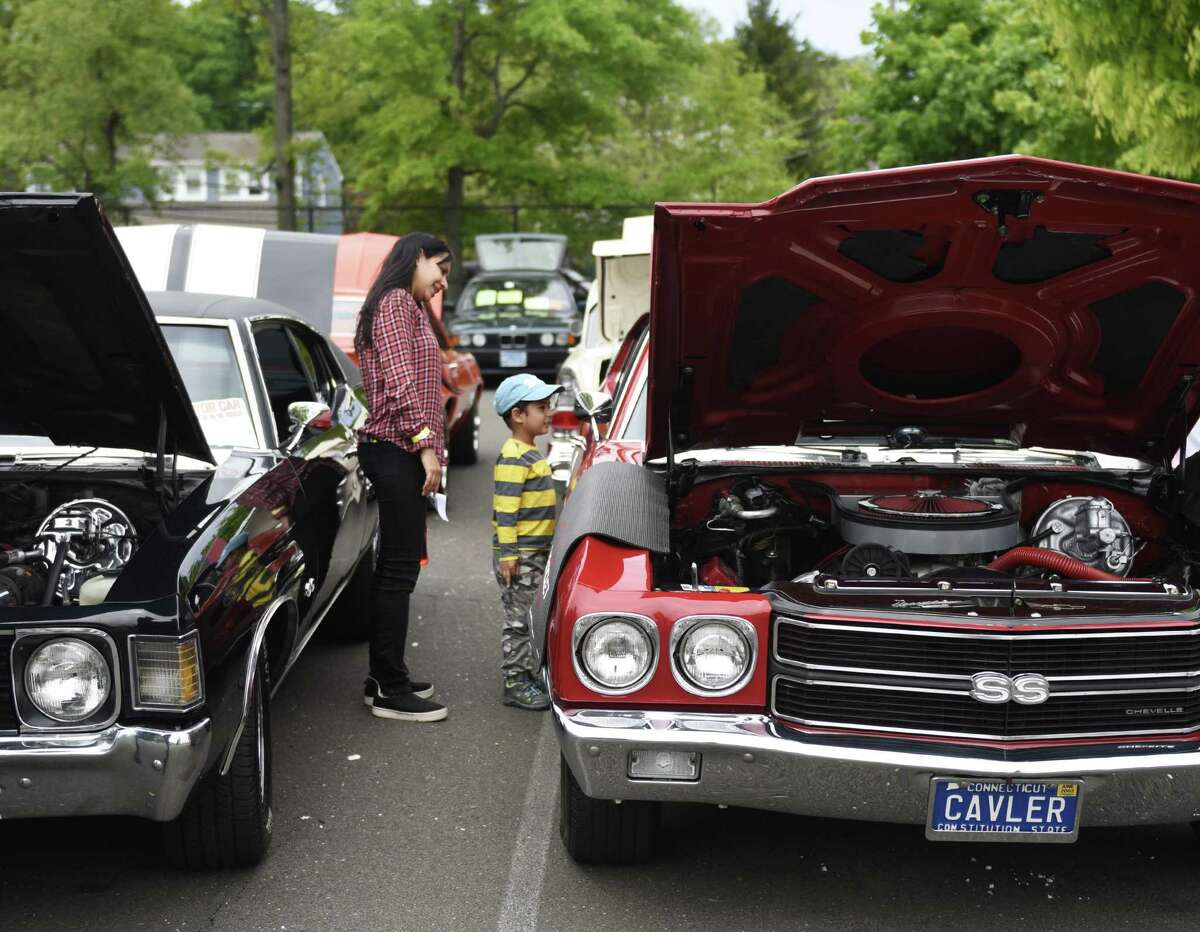 Stamford's Anoop Kaur and Evaan Ahmed, 4, look at a Chevrolet Chevelle at JM Wright Technical School's Car and Motorcycle Show Fundraiser at Scalzi Park in Stamford, Conn. Sunday, May 19, 2019. Dozens of old and new cars, as well as motorcycles, were on display at the event. Sarah Edwards, the former driver of Queen of Diamonds II jet dragster, was the show's guest of honor. Proceeds benefited the JMWT PFO for shop materials, field trips, after-school activities, scholarships, post-graduation parties and proms.