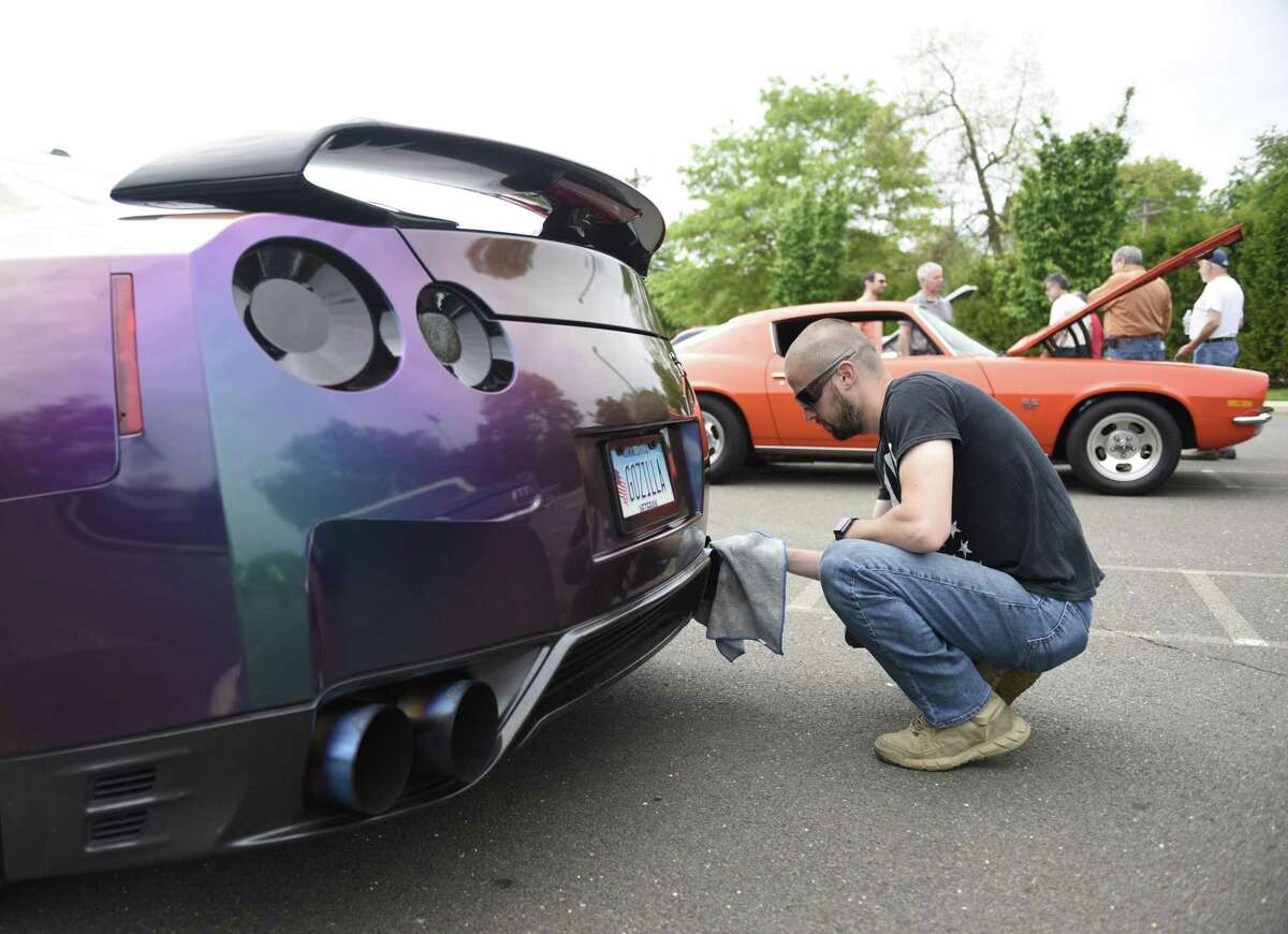 Wallingford's Richard Pierce shines up his 2016 Nissan GT-R at JM Wright Technical School's Car and Motorcycle Show Fundraiser at Scalzi Park in Stamford, Conn. Sunday, May 19, 2019. Dozens of old and new cars, as well as motorcycles, were on display at the event. Sarah Edwards, the former driver of Queen of Diamonds II jet dragster, was the show's guest of honor. Proceeds benefited the JMWT PFO for shop materials, field trips, after-school activities, scholarships, post-graduation parties and proms.