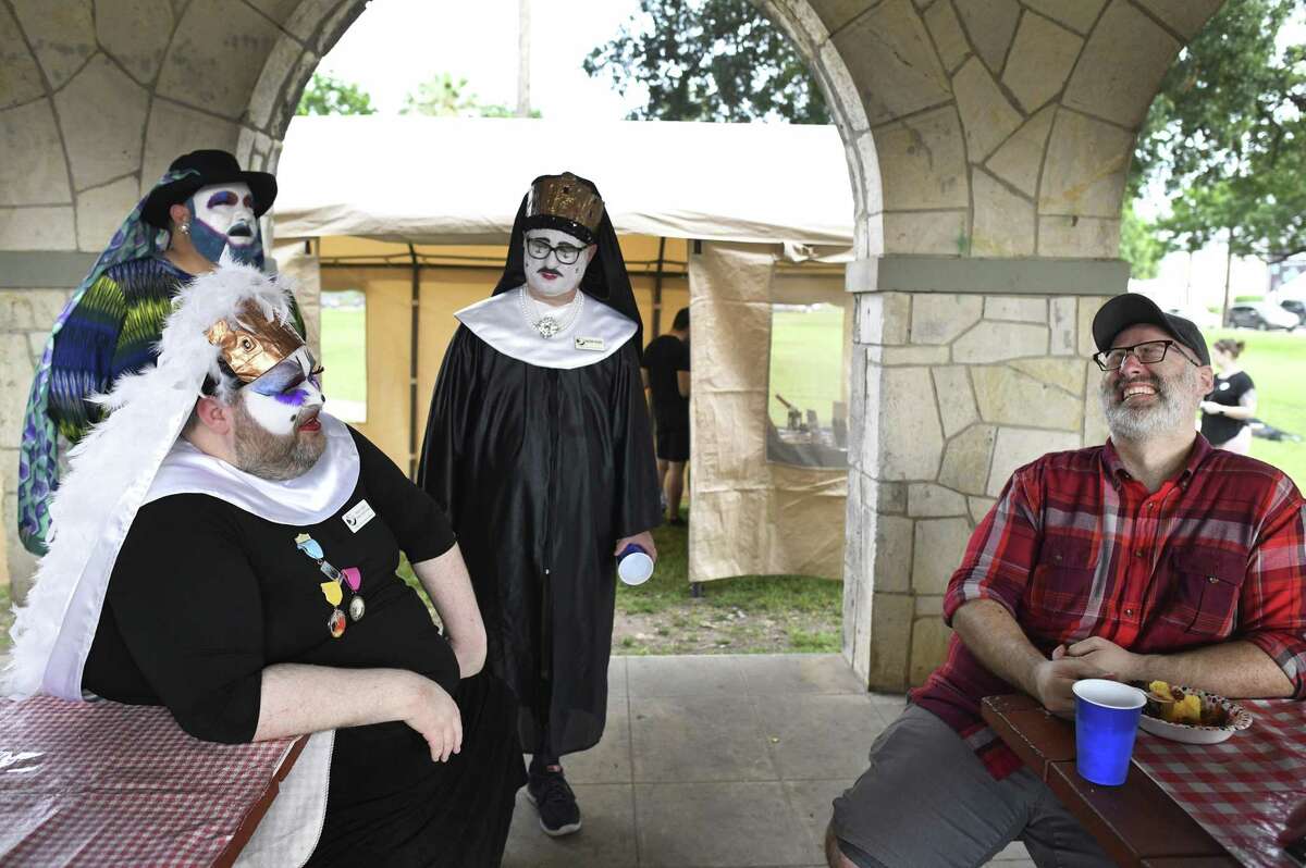 Novice Sister Minerva des People, seated at left, gets a laugh from Matt Darke as Sister Skharlott de la Noche, rear left, and Sister Eliza watch during Just One Night, a fundraiser to help San Antonio’s homeless youth that was held Saturday evening at Maverick Park. The event was sponsored by nonprofit called San Antonio Sisters of Perpetual Indulgence. Members wear nun habits and face paint to draw the public’s attention to their causes. The three members didn’t provide their real names.