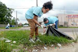 David and his father William Sames help remove trash and other debris in the neighborhood near the John Paul Davis Community Center during Saturday's city-wide Trash Off 2019. Volunteers were stationed in areas throughout the city identified by code enforcement officials as areas in need of clean-up. Photo taken Saturday, May 18, 2019 Kim Brent/The Enterprise