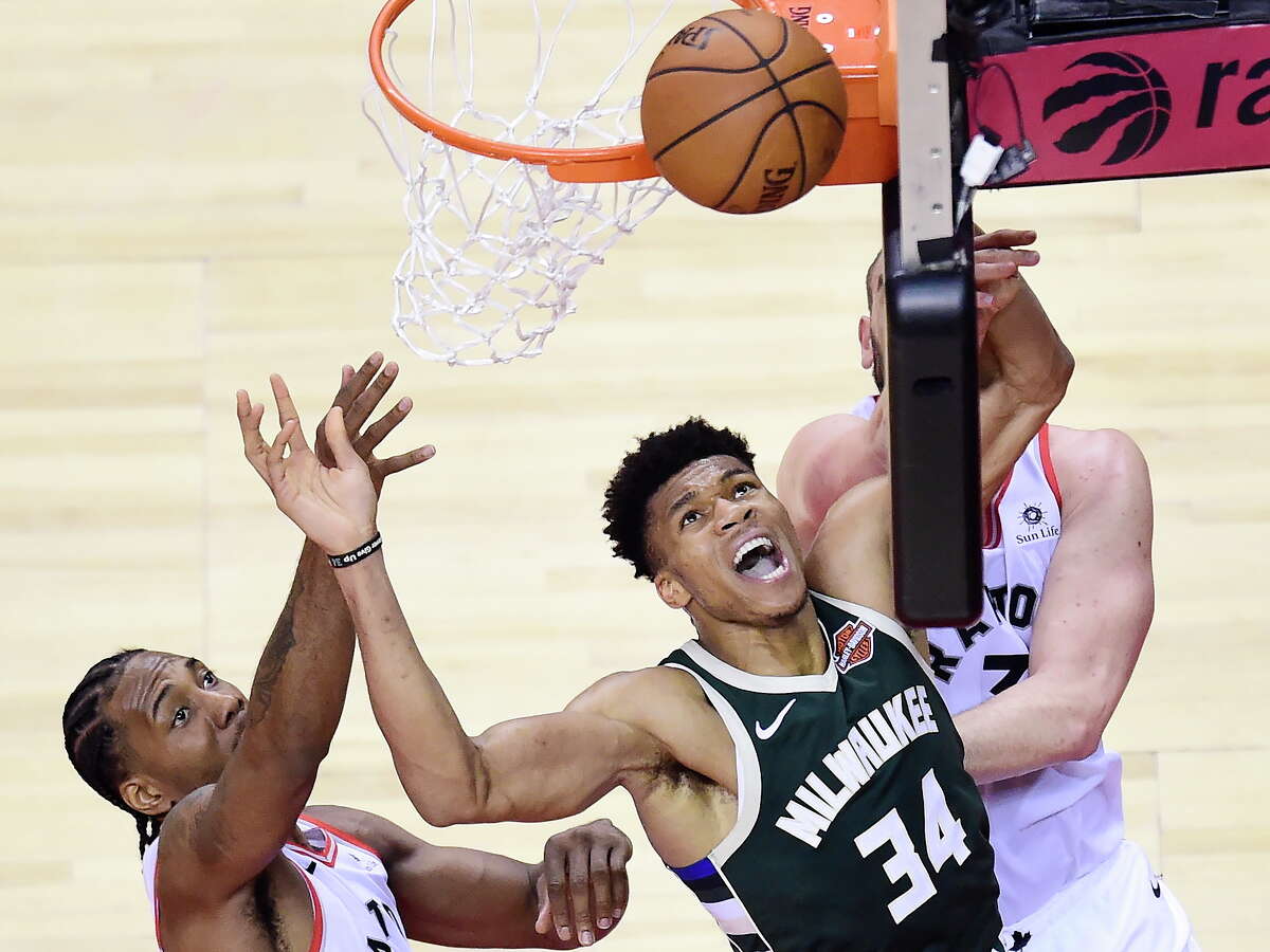 Milwaukee Bucks forward Giannis Antetokounmpo (34) misses a basket under pressure from Toronto Raptors forward Kawhi Leonard, left, and center Marc Gasol, back right, during the second half of Game 3 of the NBA basketball playoffs Eastern Conference finals in Toronto, Sunday, May 19, 2019. (Frank Gunn/The Canadian Press via AP)