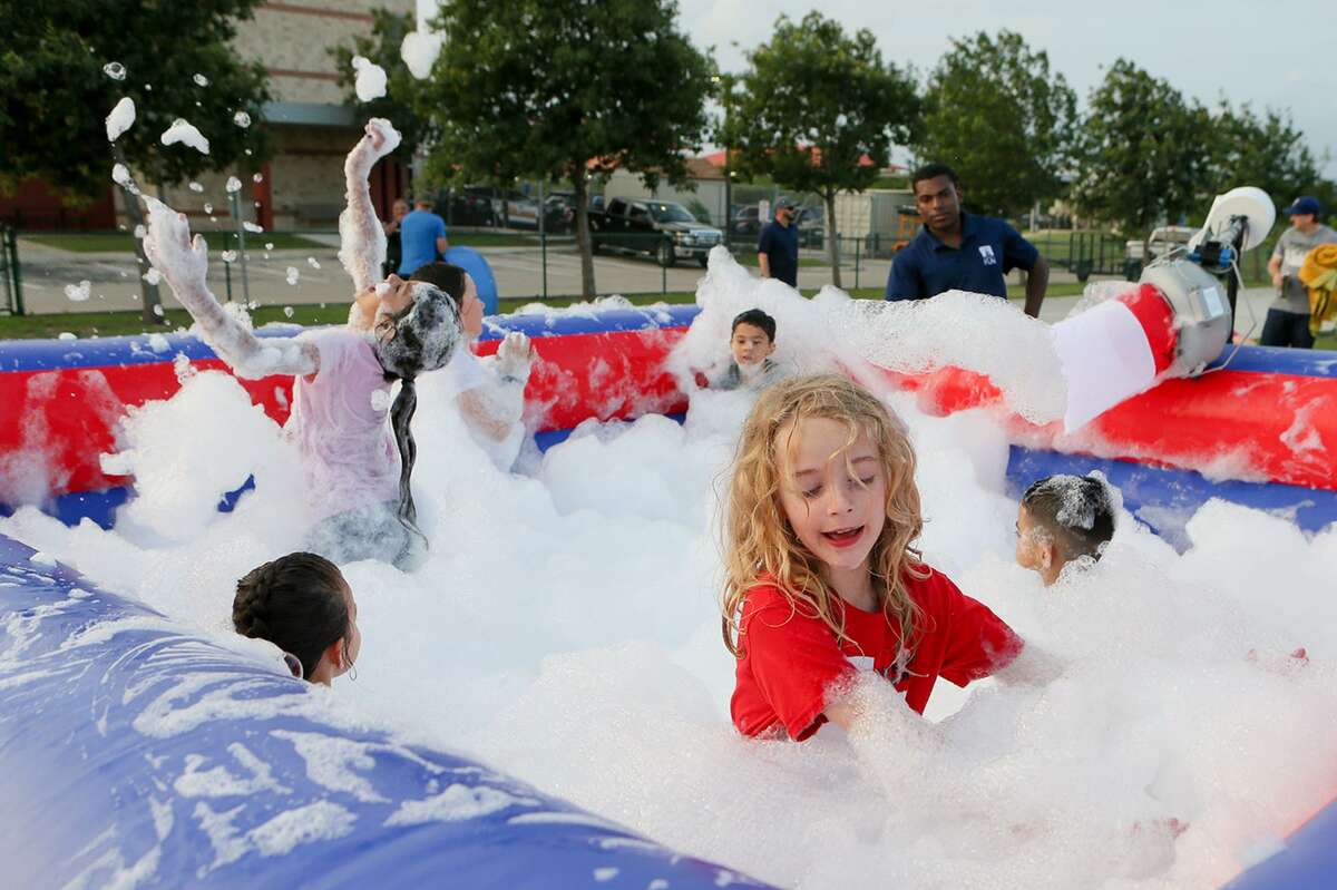 Sara Turner, front right, plays with other children in a foam and bubble-filled bounce house during Cibolo Summer Nights at the Cibolo Multi-Event Center on Friday. The event was this year’s kickoff of the Cibolo Summer Nights, a free community-centered program that includes family-friendly activities and movie screenings.