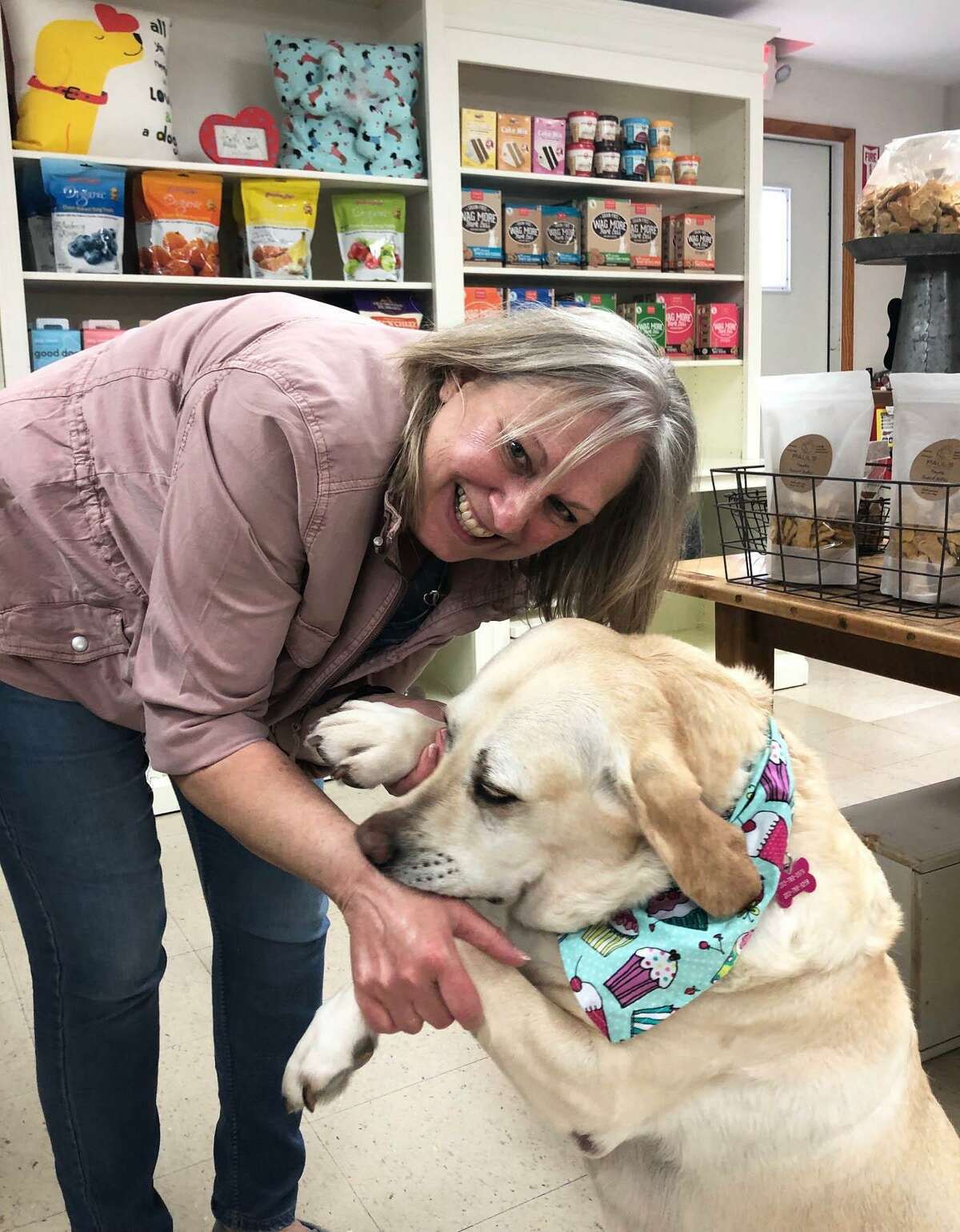 Spectrum/Debbie Bauman, owner of The Barkery Boo’tique in New Milford has moved the business from Bank Street to 92 Park Lane Road (Route 202). Bauman is shown above with her dog, Daisy, an 8-year-old Yellow Lab, who is the store’s “official greeter and taste tester.” May 2019