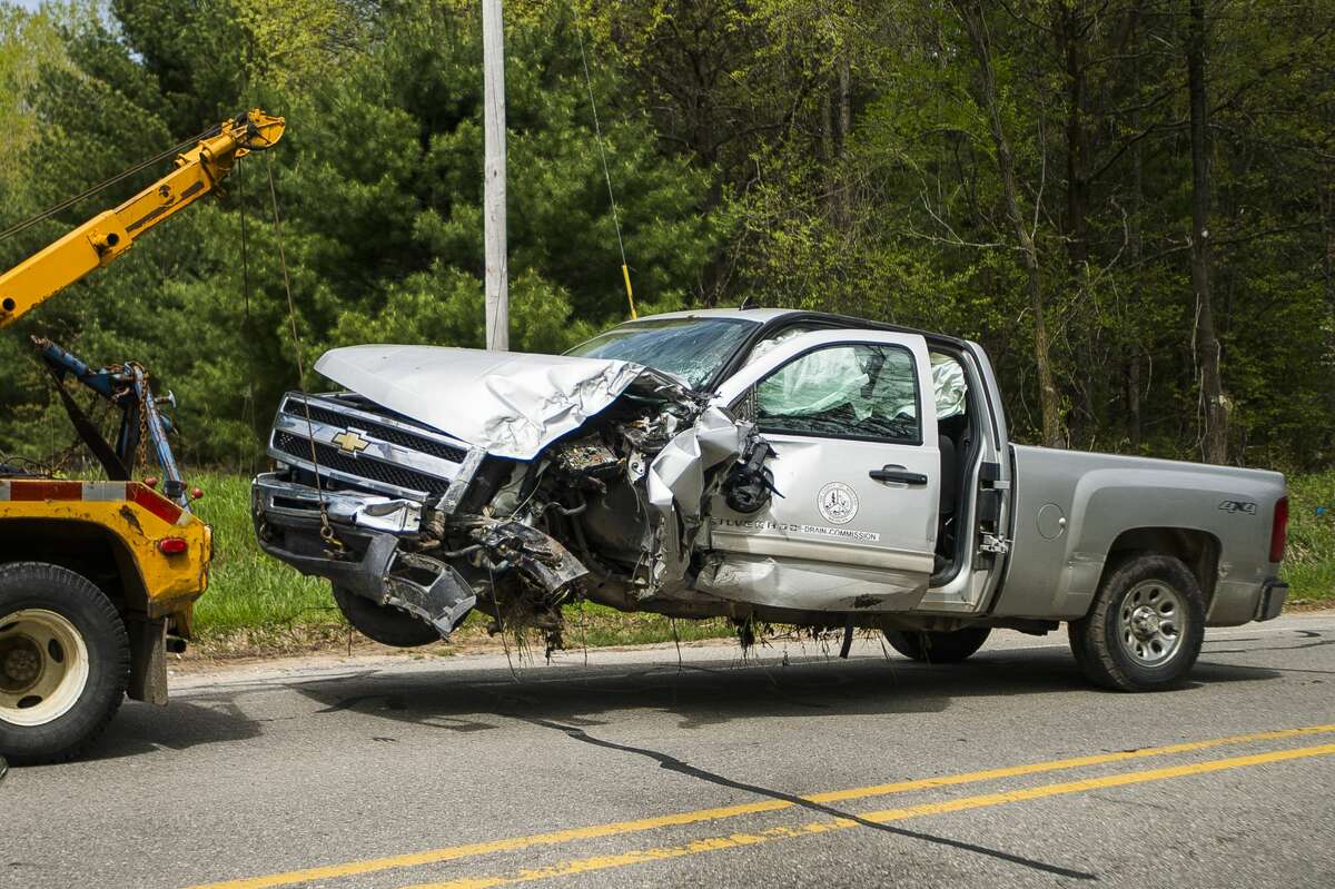A tow truck pulls a Midland County Drain Commission vehicle from the scene after it was involved in a crash on N. West River Road near Gage Road in Sanford on Tuesday, May 21, 2019. According to Captain Tracy Thomas of the Midland County Sheriff's Office, the driver suffered minor injuries. (Katy Kildee/kkildee@mdn.net)