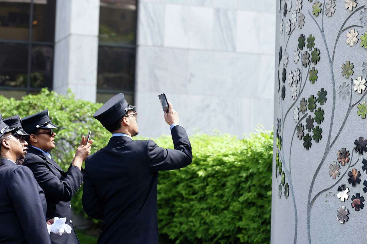 NYS Emergency Medical Service members take a look at the Tree of Life Memorial during a ceremony commemorating the lives of seven first responders on Tuesday, May 21, 2019 at the Empire State Plaza in Albany, NY. (Phoebe Sheehan/Times Union)