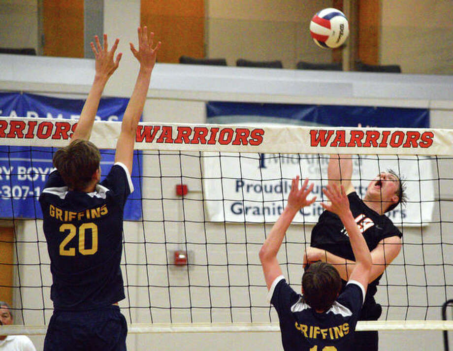 Edwardsville’s Josh Whittenburg, right, goes up for a kill against Father McGivney’s Caleb Tanzyus during Tuesday’s semifinal match in the Granite City Regional. Photo: Scott Marion/The Intelligencer