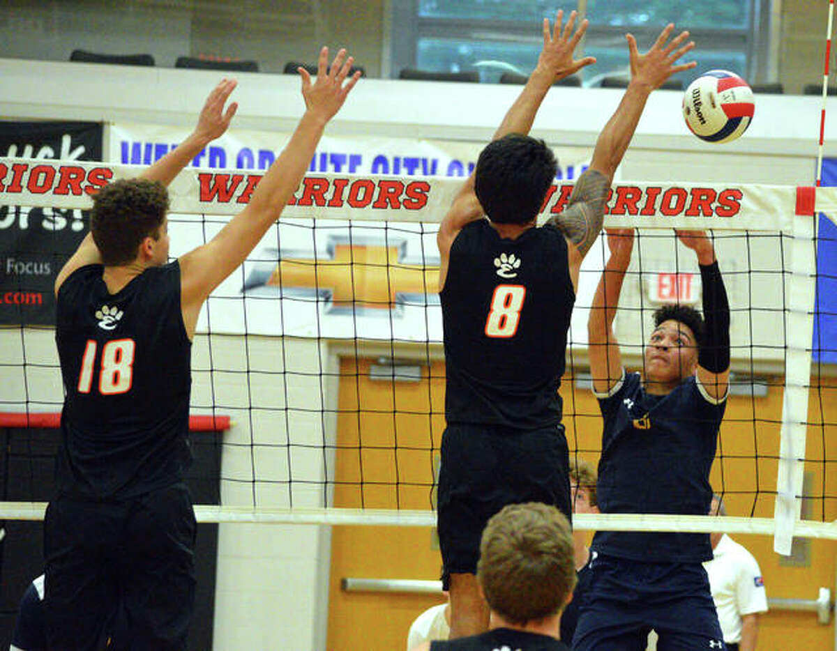 Father McGivney’s Andrew Nwacha, tries to go up for a kill against Edwardsville’s Sam Stearns, left, and Eric Epenesa during Tuesday’s semifinal match in the Granite City Regional.