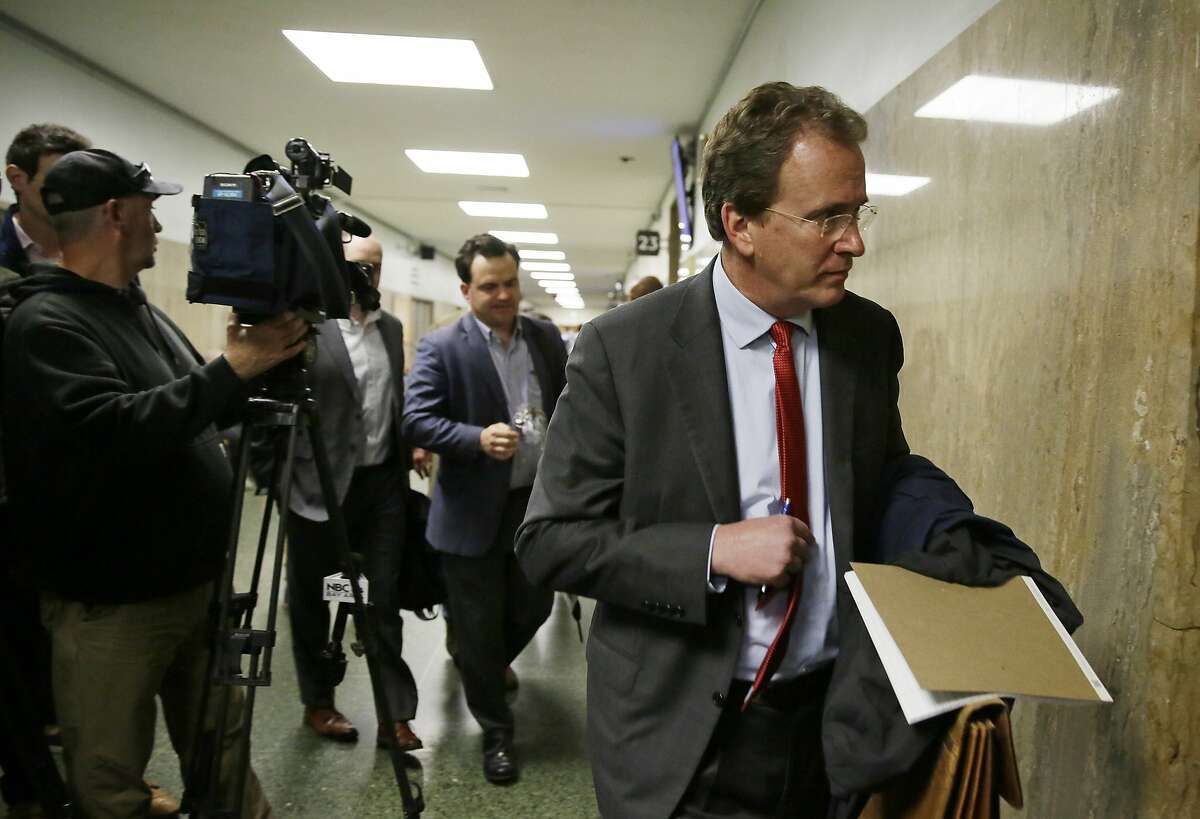 Thomas Burke, attorney for freelance journalist Bryan Carmody, followed by David Snyder, First Amendment Coalition Executive Director, make their way into a courtroom Tuesday, May 21, 2019, in San Francisco. A San Francisco police attorney said that Carmody, whose office and work equipment was seized in a police raid, can collect his property although the legal issues surrounding the case were not resolved Tuesday. San Francisco Superior Court Judge Samuel Feng set dates to hear separate motions to quash search warrants used to raid the home of Carmody and to unseal those warrants. (AP Photo/Eric Risberg)