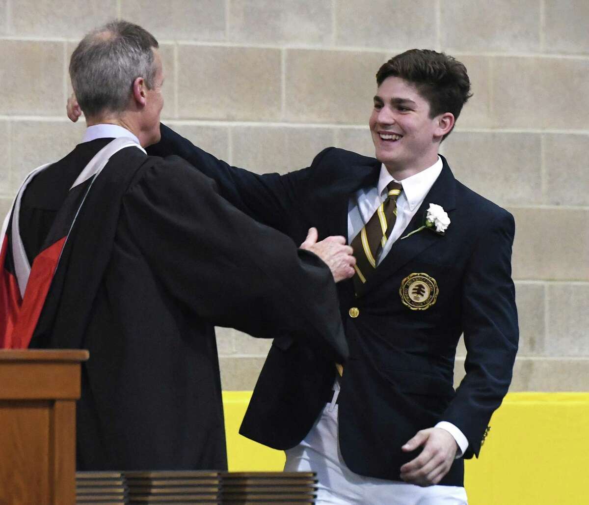 Cooper Moore hugs Headmaster Thomas Philip before accepting his diploma at the Brunswick School 117th Commencement at Brunswick's School's Dann Gymnasium in Greenwich, Conn. Wednesday, May 22, 2019. Retired Supreme Court Associate Justice Anthony M. Kennedy gave the commencement speech before 100 new graduates walked across the stage.