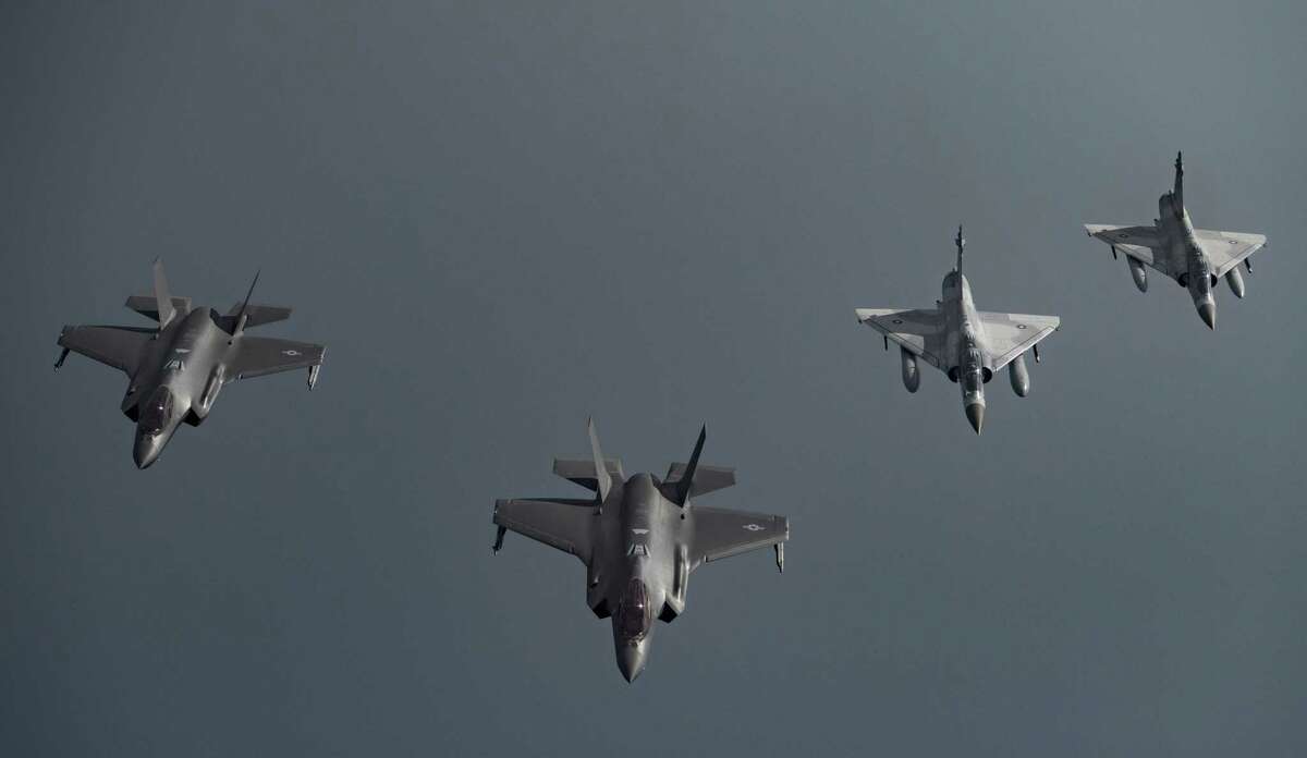 In this Tuesday, May 21, 2019 photo, Qatari Air Force Mirage 2000s, right, and U.S. F-35A Lightning IIs fly in formation over Southwest Asia in undisclosed location. (Senior Airman Keifer Bowes/U.S. Air Force via AP)