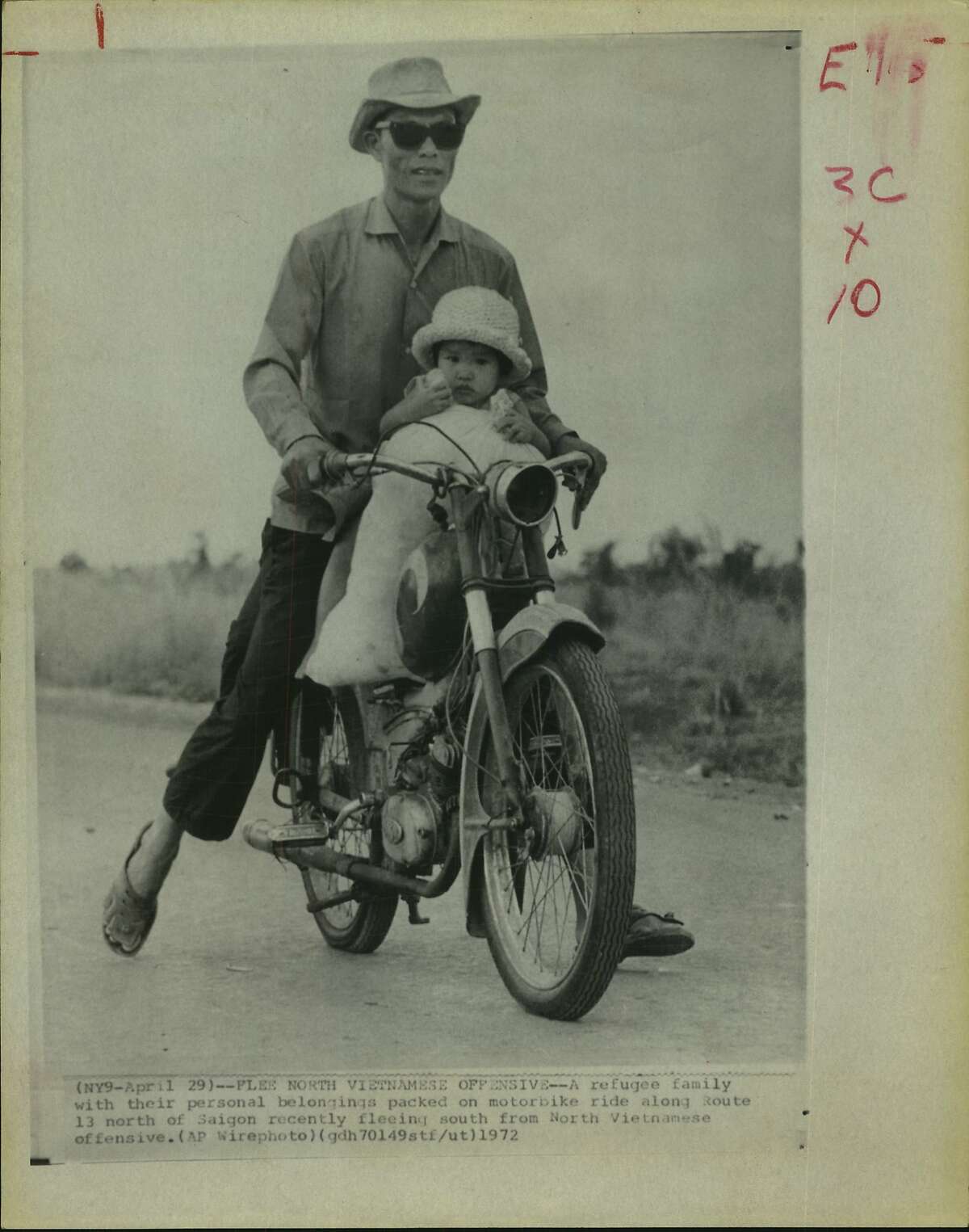 A refugee family with their personal belongings packed on motorbike ride along Route 13 north of Saigon recently fleeing south from North Vietnamese offensive. Meager belongings were carried in a sack. South Vietnamese Refugees